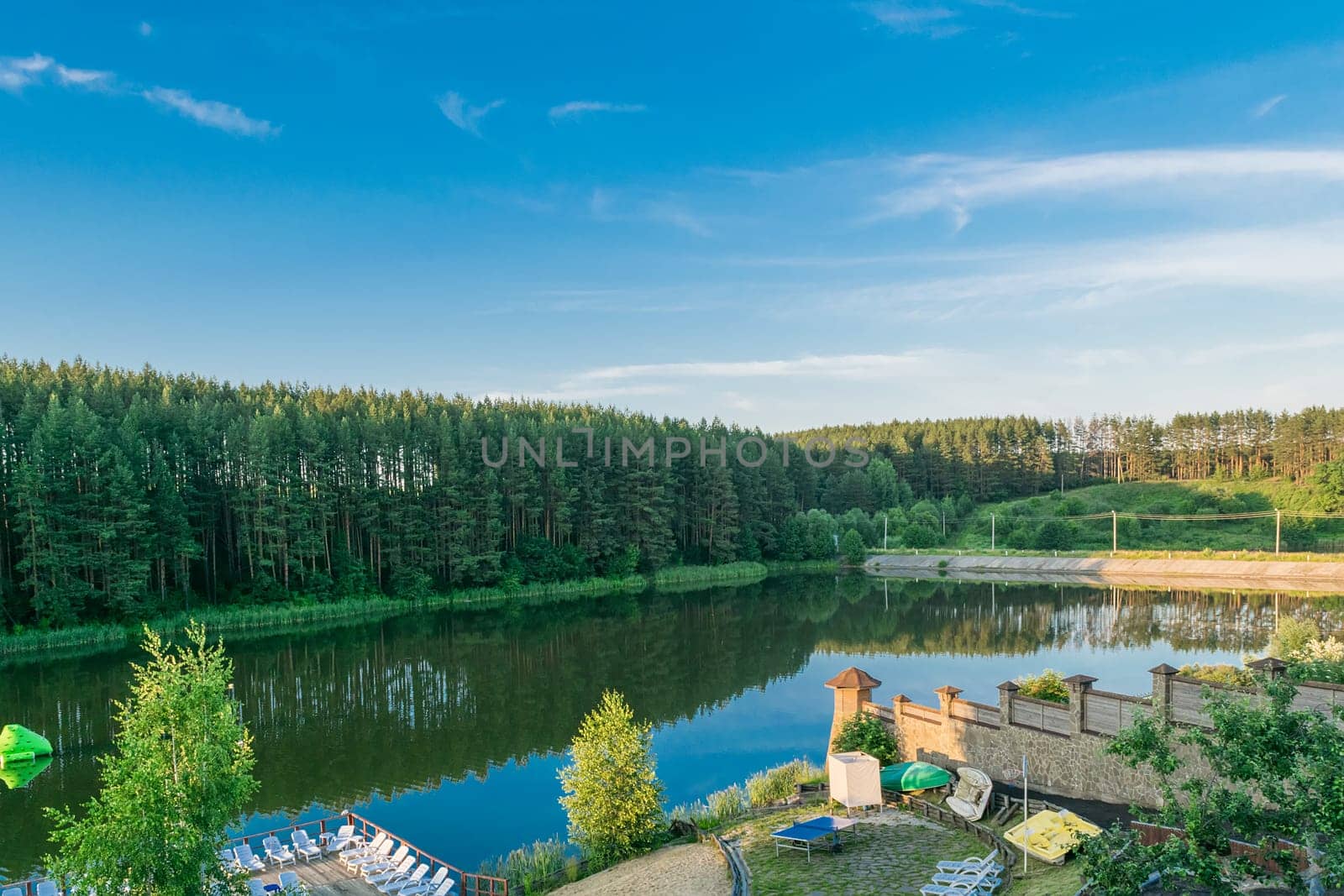Resting place on the beach on the shores of an artificial lake near the edge of the forest