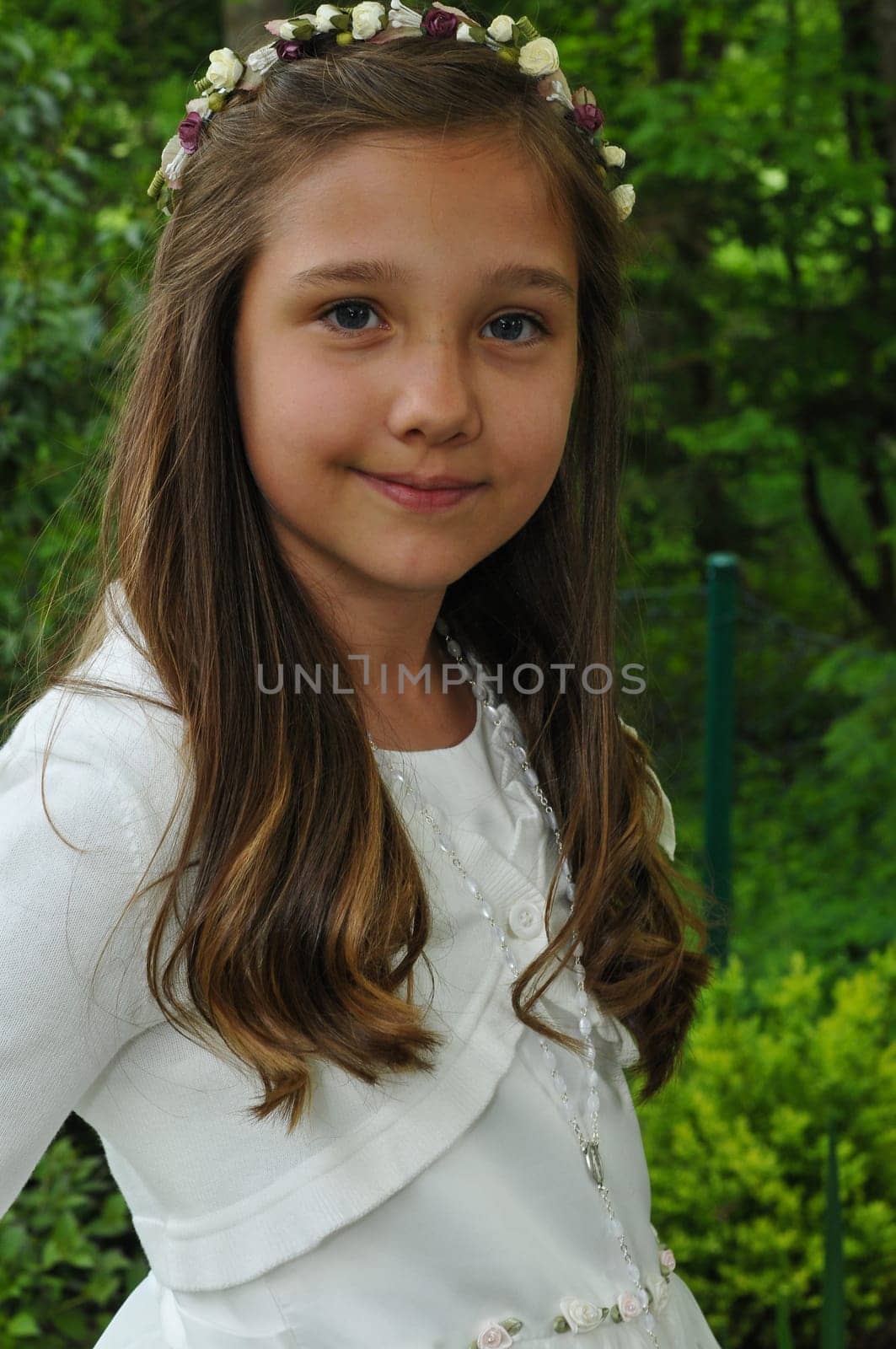 Girl before communion festively dressed in the garden