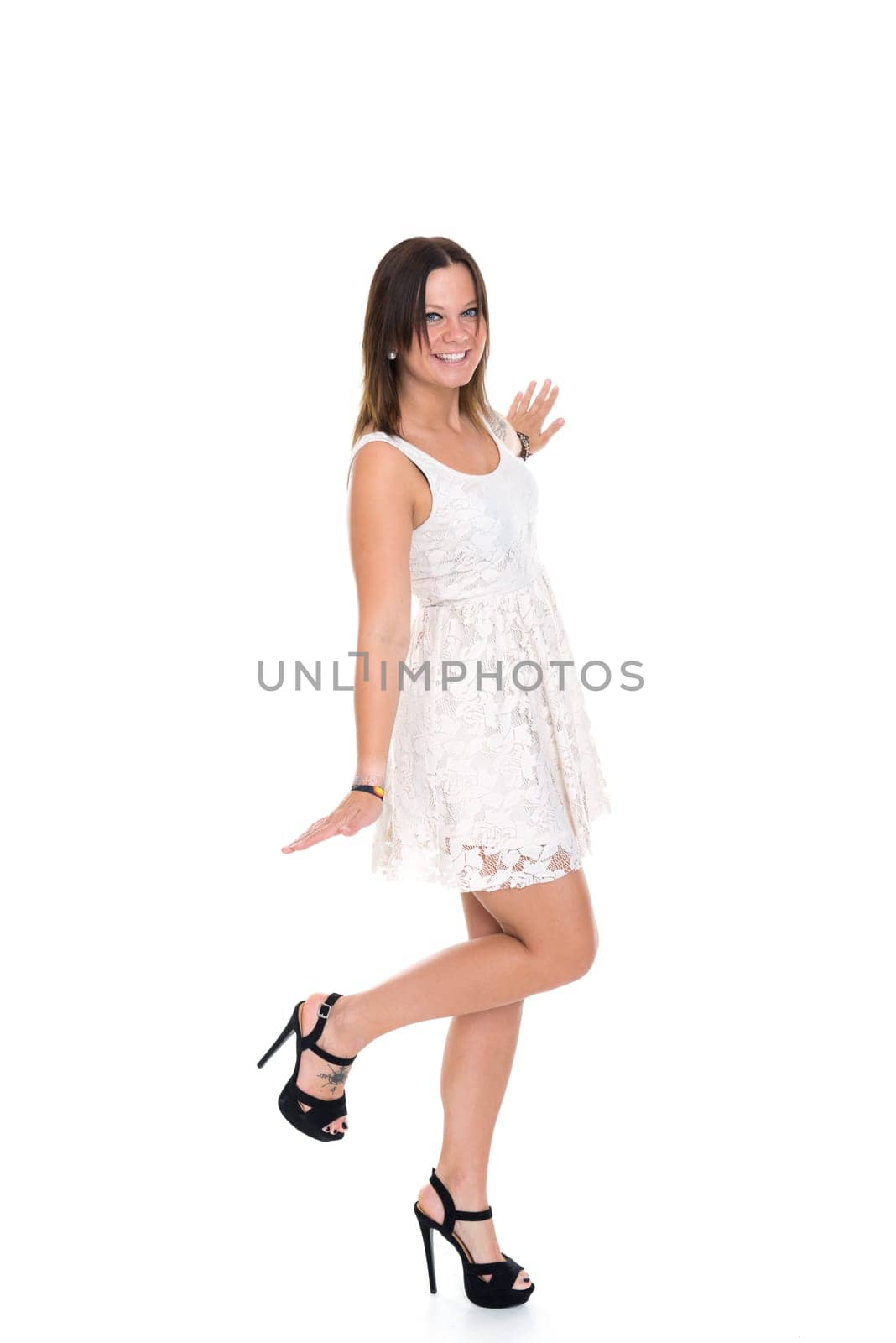 pretty young woman in short gown and high heels in front of white background