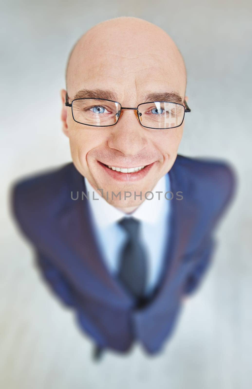 Face of smiling businessman in eyeglasses looking at camera
