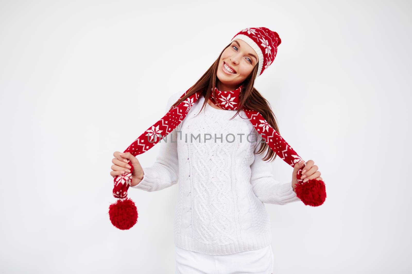 Happy girl in cap, sweater and scarf looking at camera