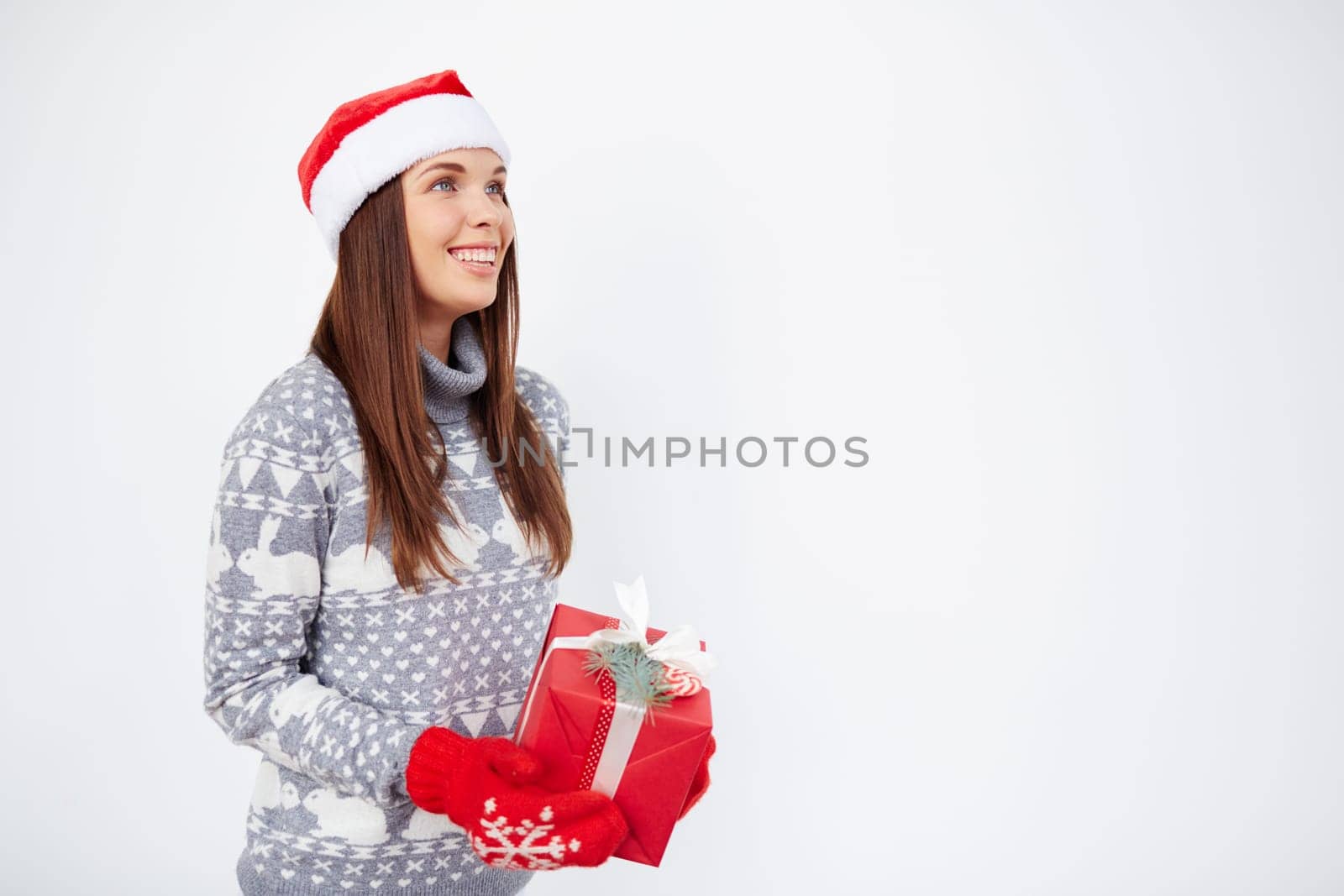 Happy woman with Christmas gift standing in isolation