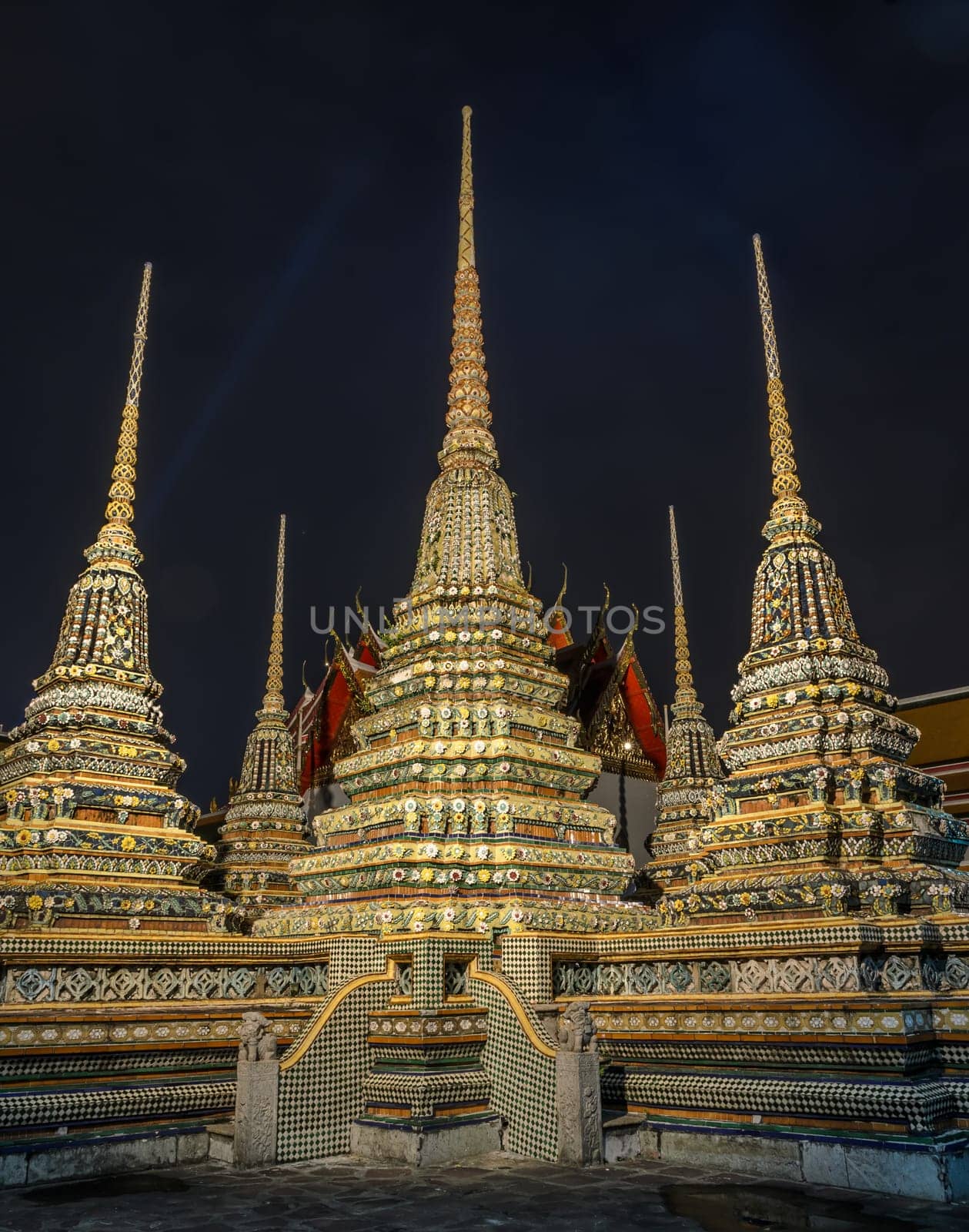 Rich decorated pagoda at Wat Pho temple at night lighting in Bangkok, Thailand