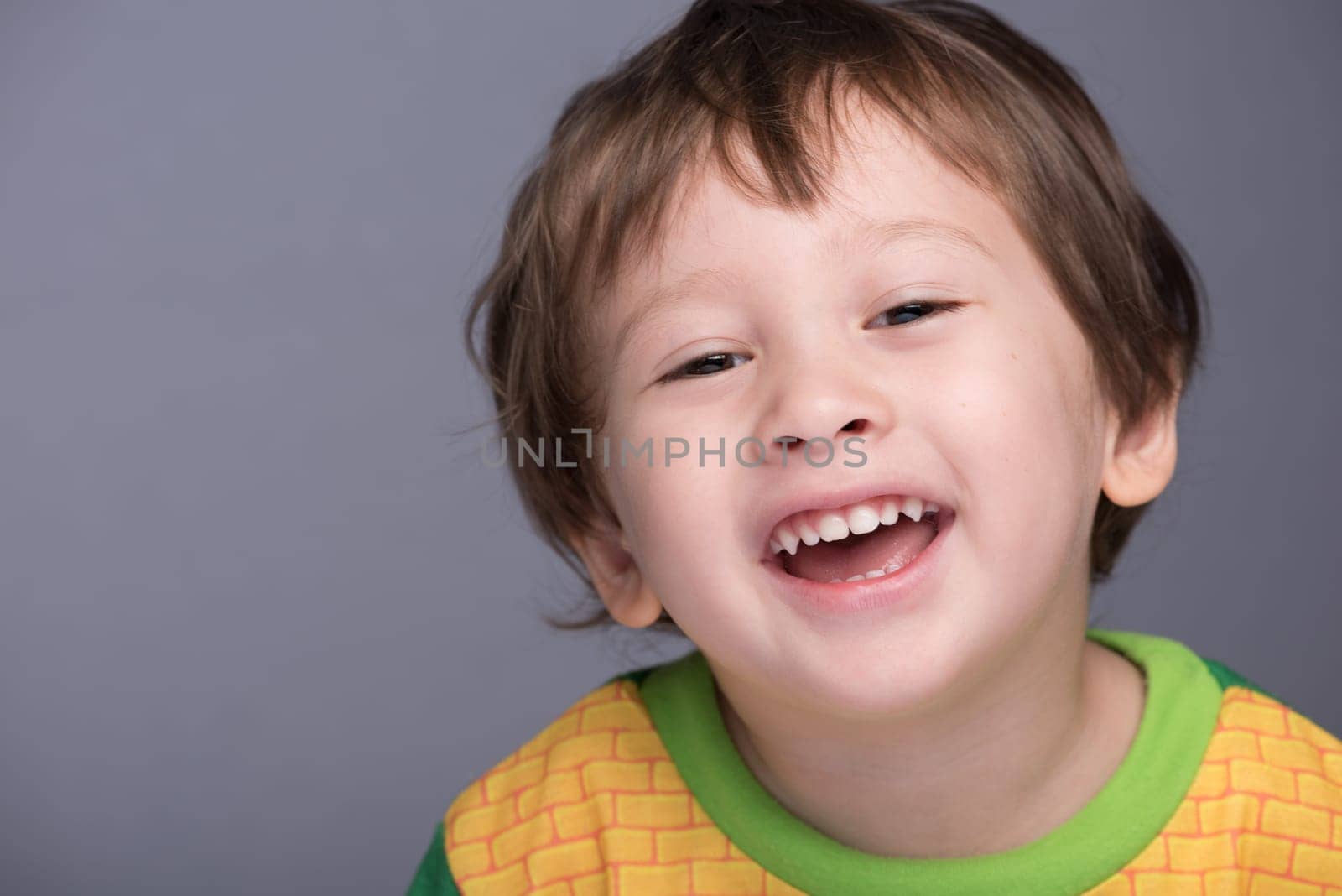 A happy 3 year old Japanese/Caucasian boy smiling.