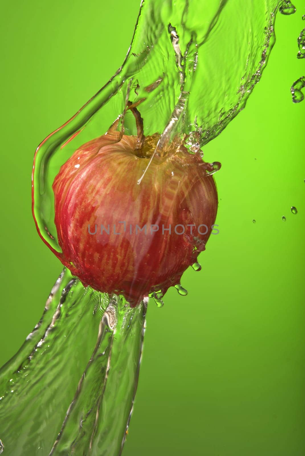 Healthy living organic apple on green background with water splash. Ideal for exercise campaign or poster. .