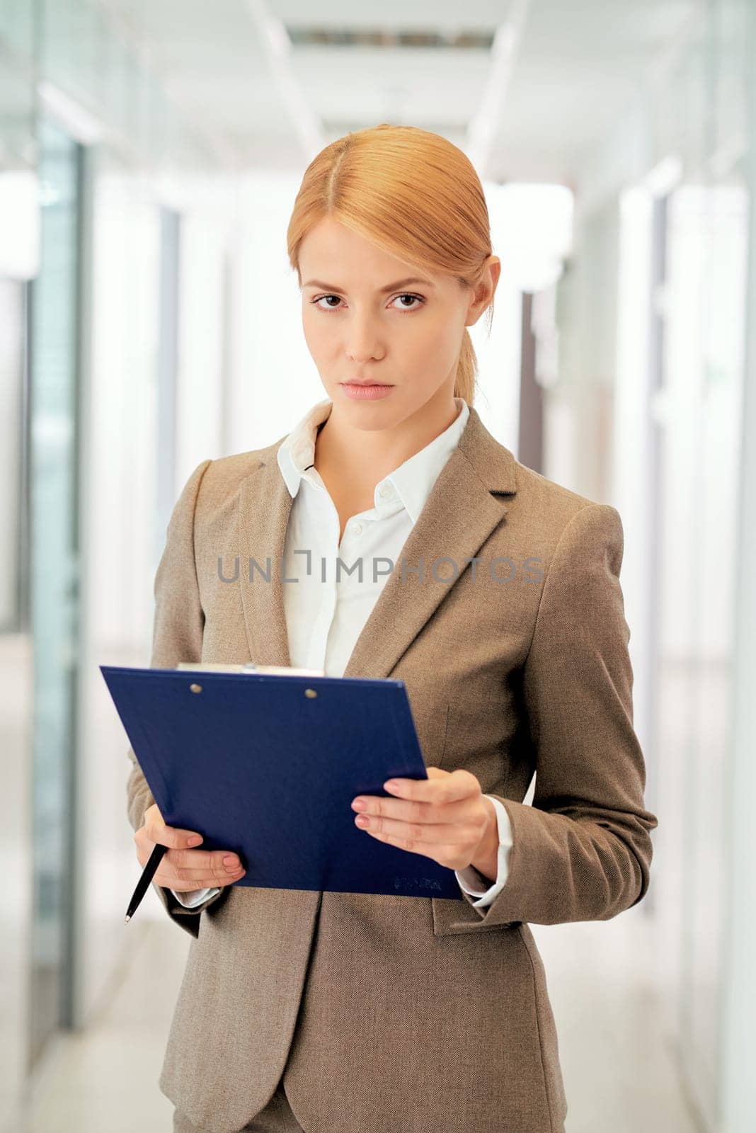 Elegant businesswoman holding clipboard with document