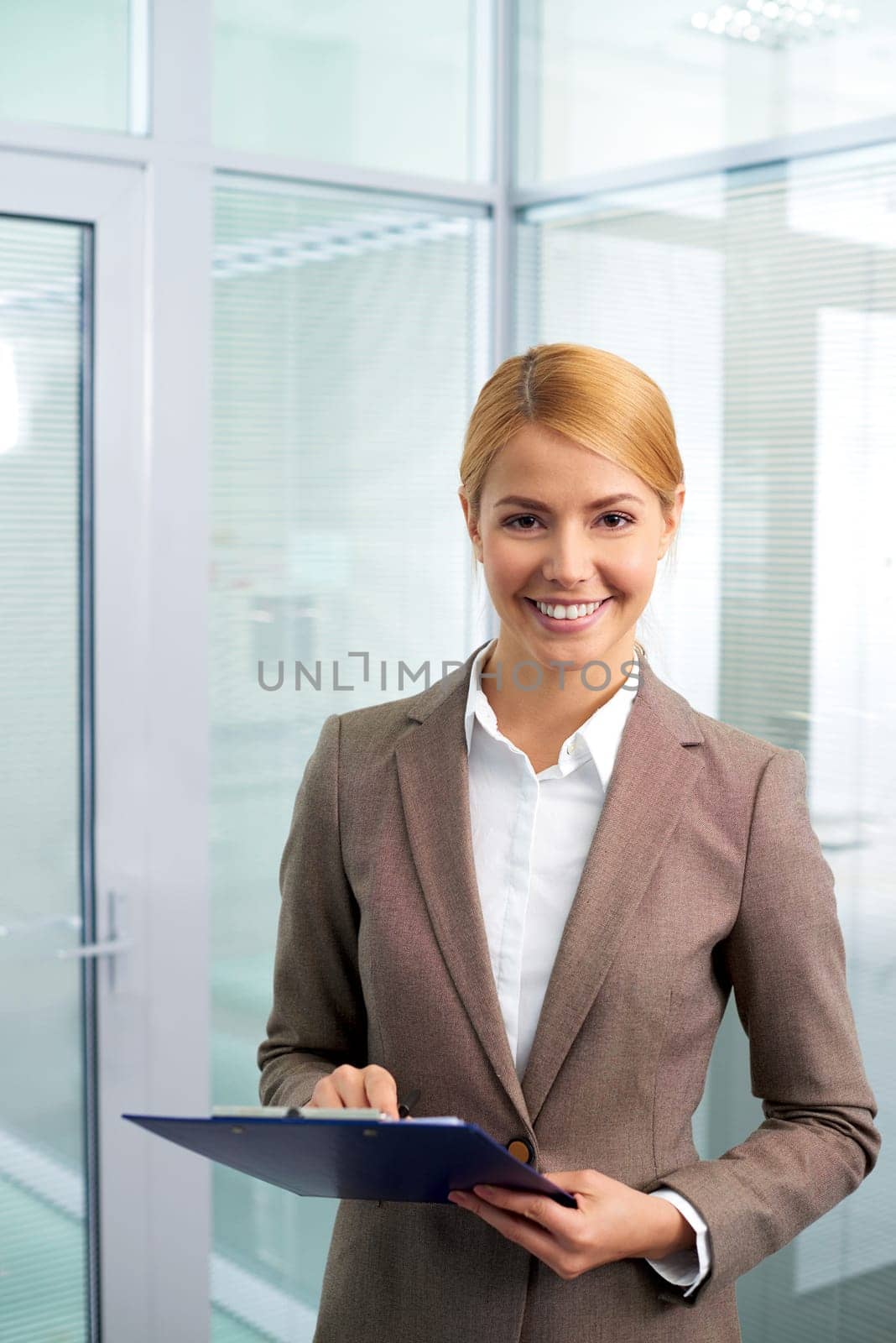 Happy businesswoman looking at camera in office
