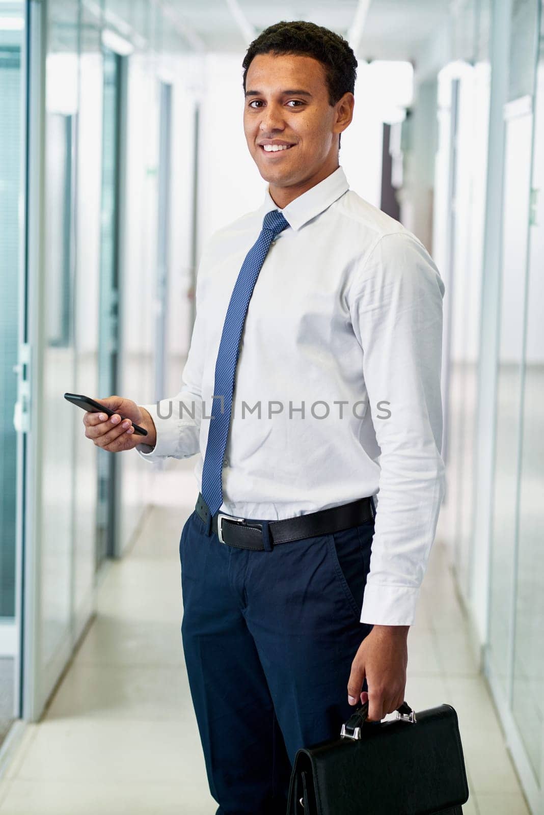 Elegant businessman briefcase and cellphone looking at camera