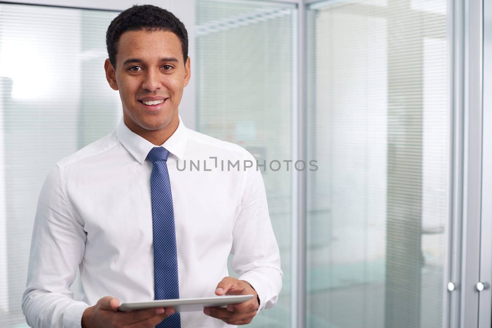 Young businessman with touchpad looking at camera with smile