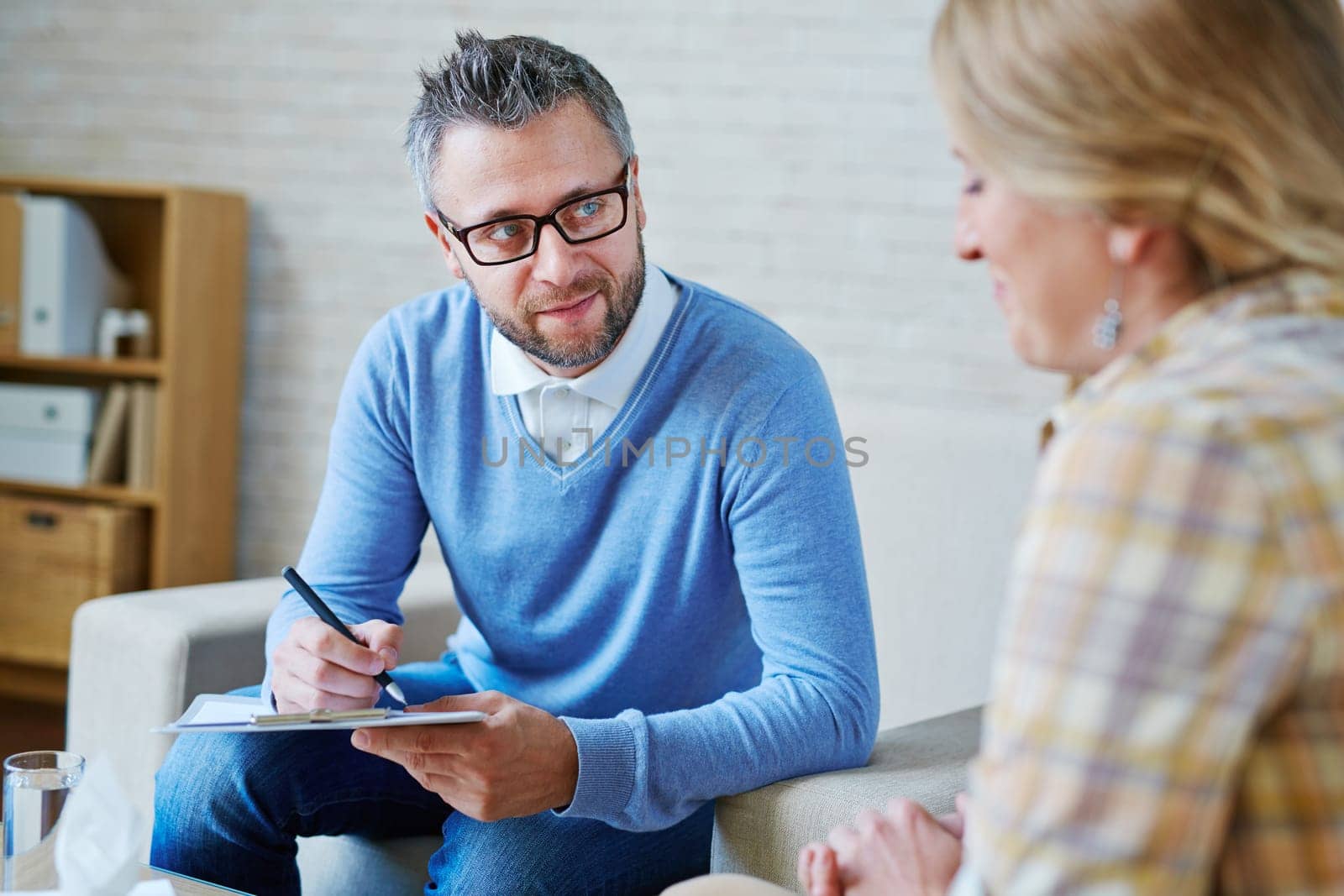 Male psychiatrist looking at patient during her visit