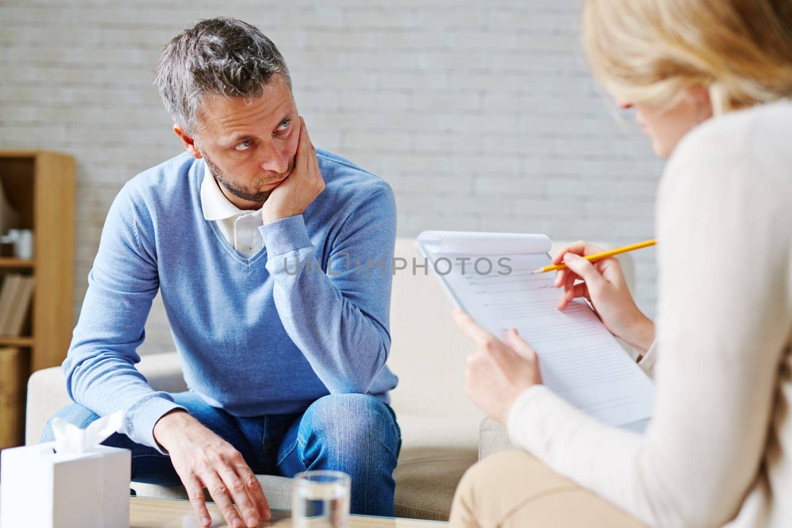 Tense man looking at his psychologist during consultation