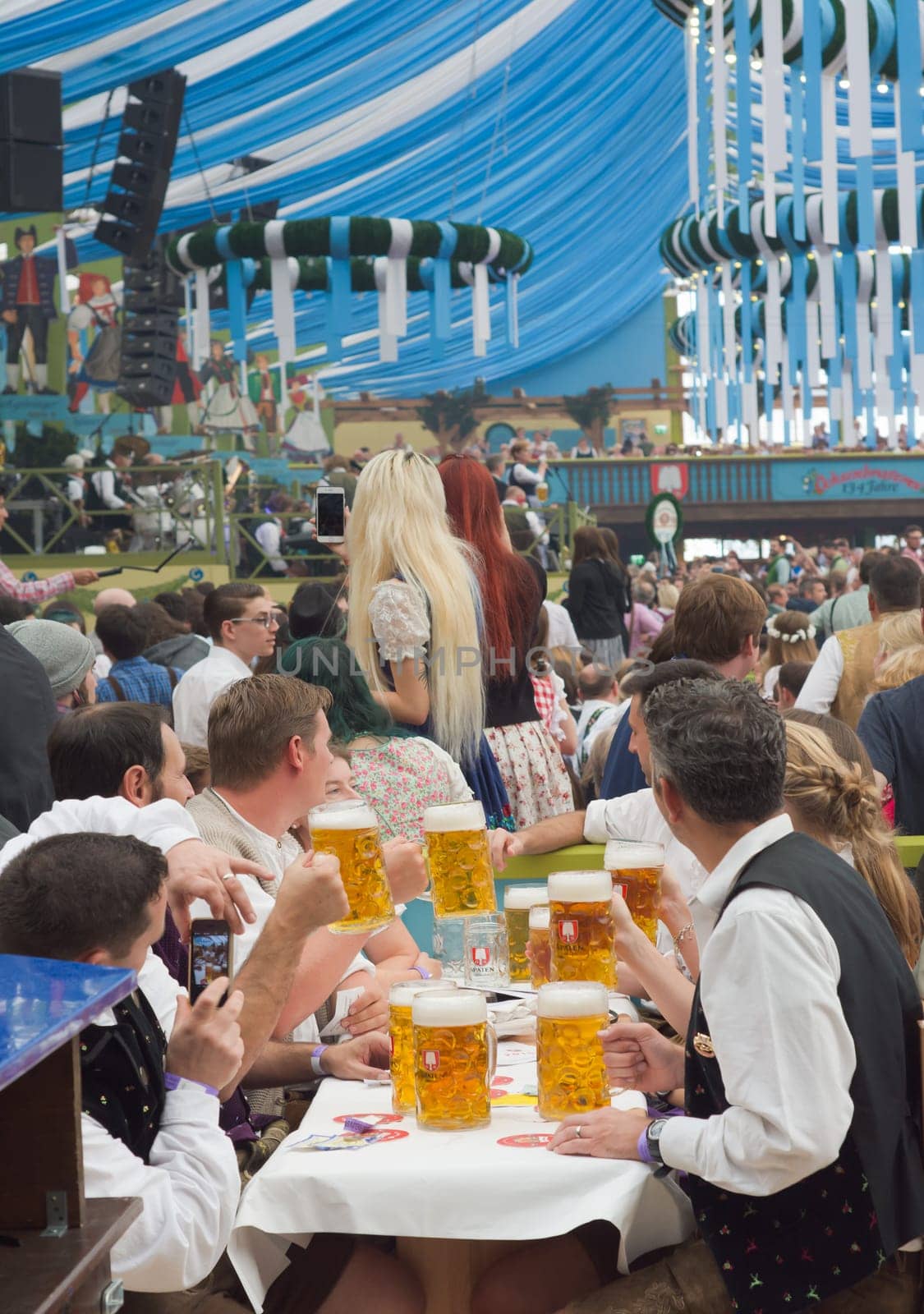 MUNICH, GERMANY – SEPT. 19, 2015:  Oktoberfest Crowds of visitors at the Spatenbrau Tent celebrating the festivities and beer. The Festival runs from September 19th until October 4th 2015 in Munich, Germany