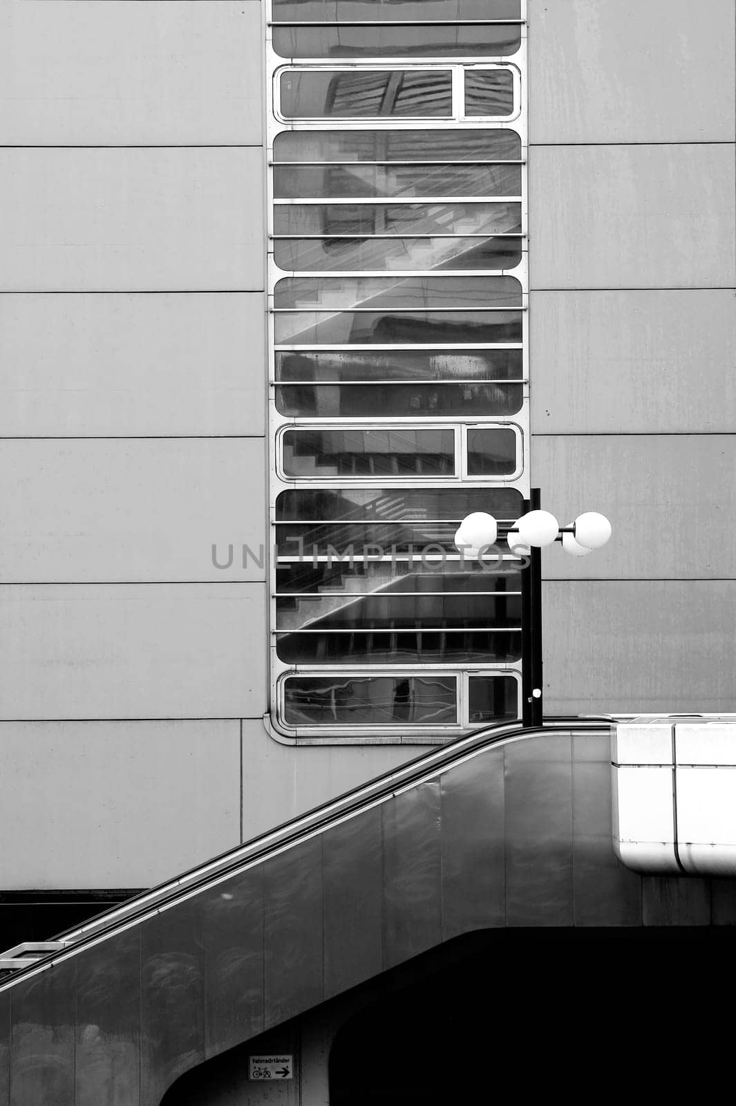 A lantern stands in front of a shiny tin facade with a stairway and an external staircase made of corrosion-free steel.