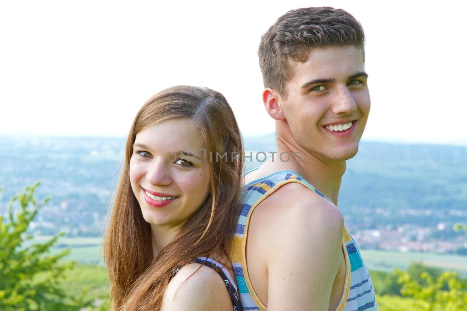 Young,happy couple back to back in nature