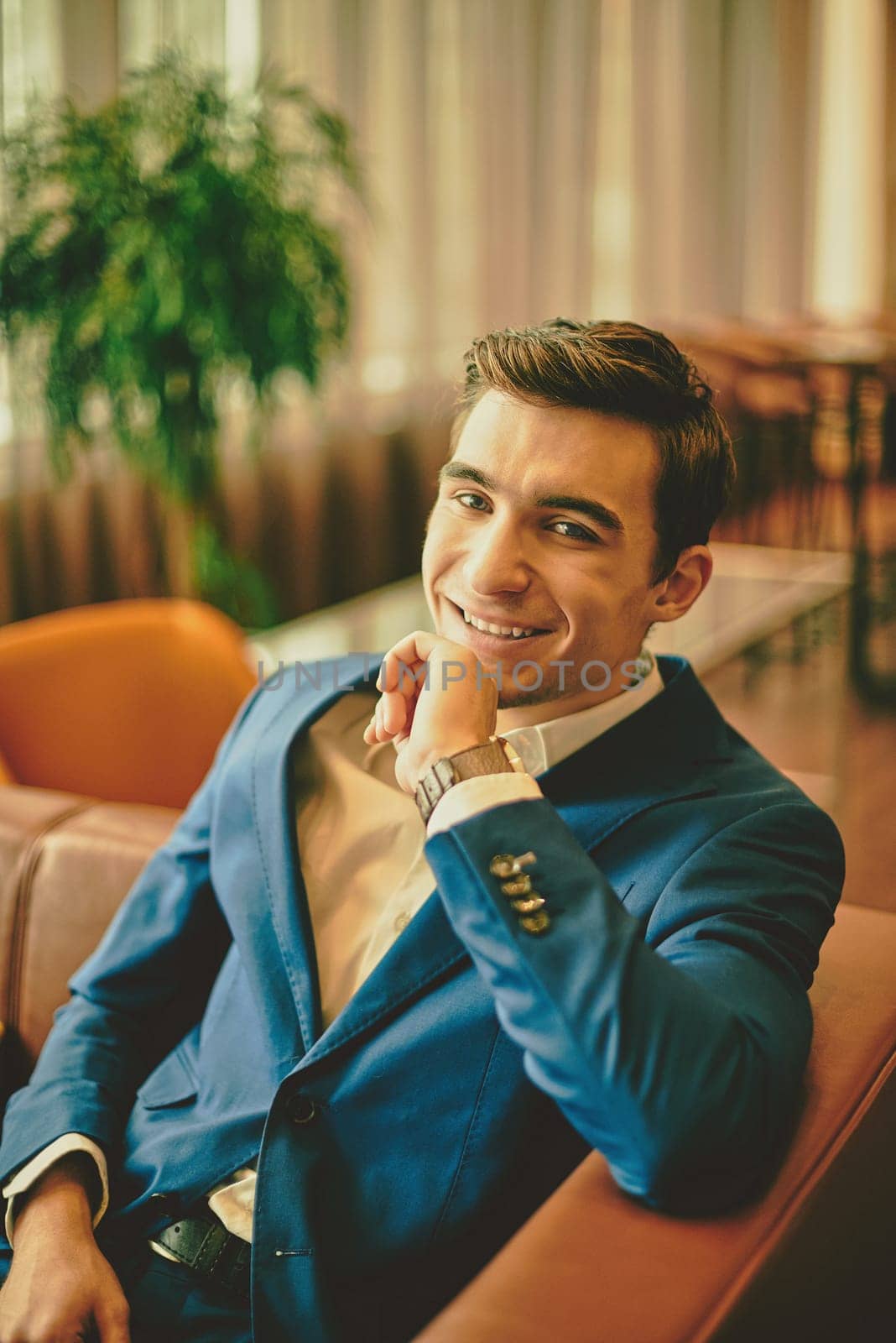 Happy young businessman looking at camera