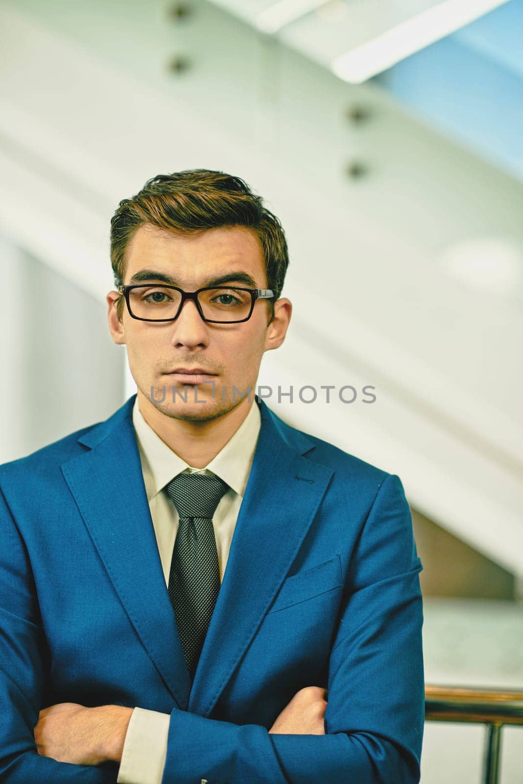 Serious employee in formalwear and eyeglasses looking at camera