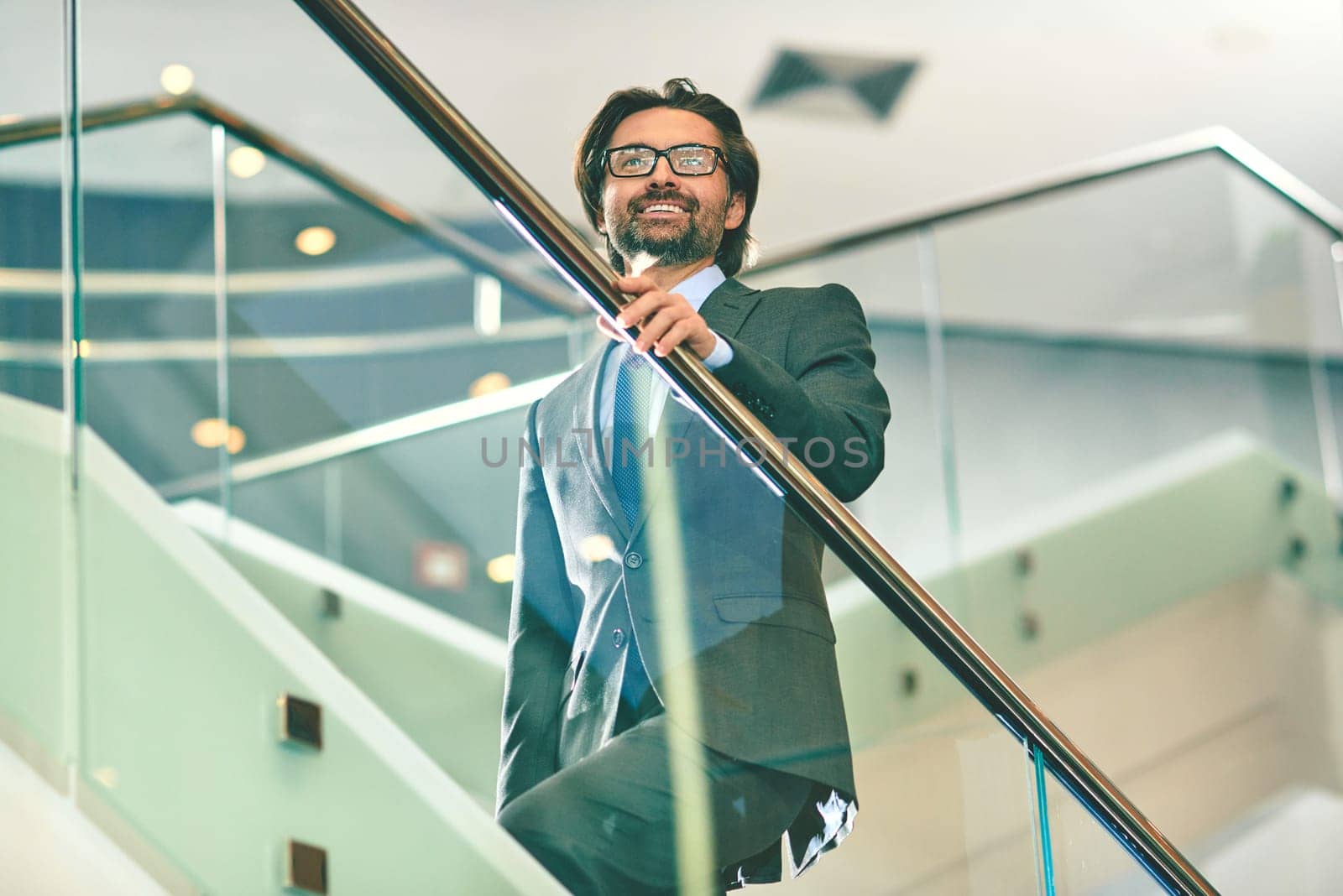 Mature businessman going upstairs inside office building
