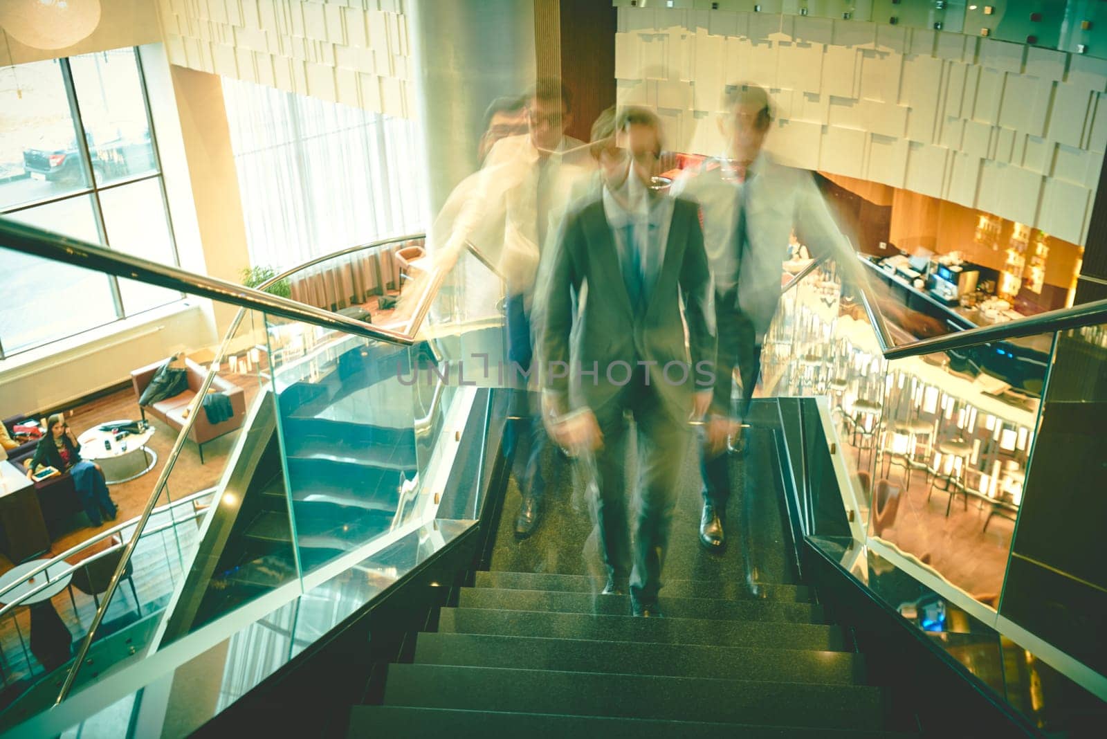 Blurred outlines of businessmen going upstairs