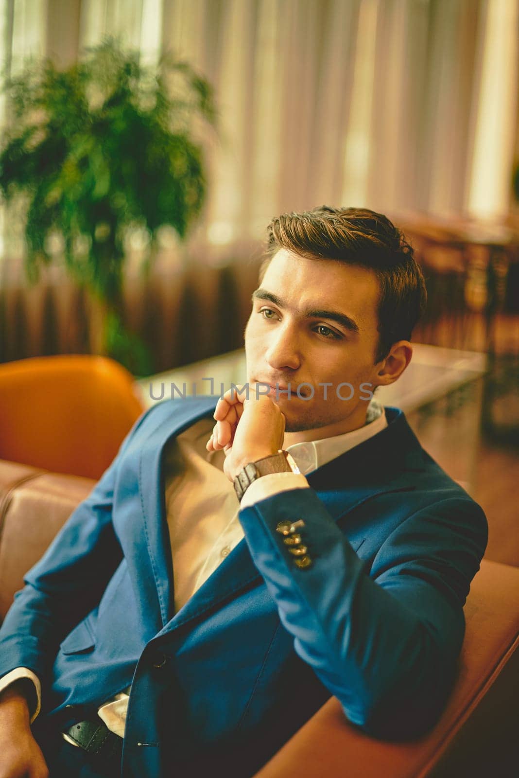 Young handsome businessman sitting on sofa