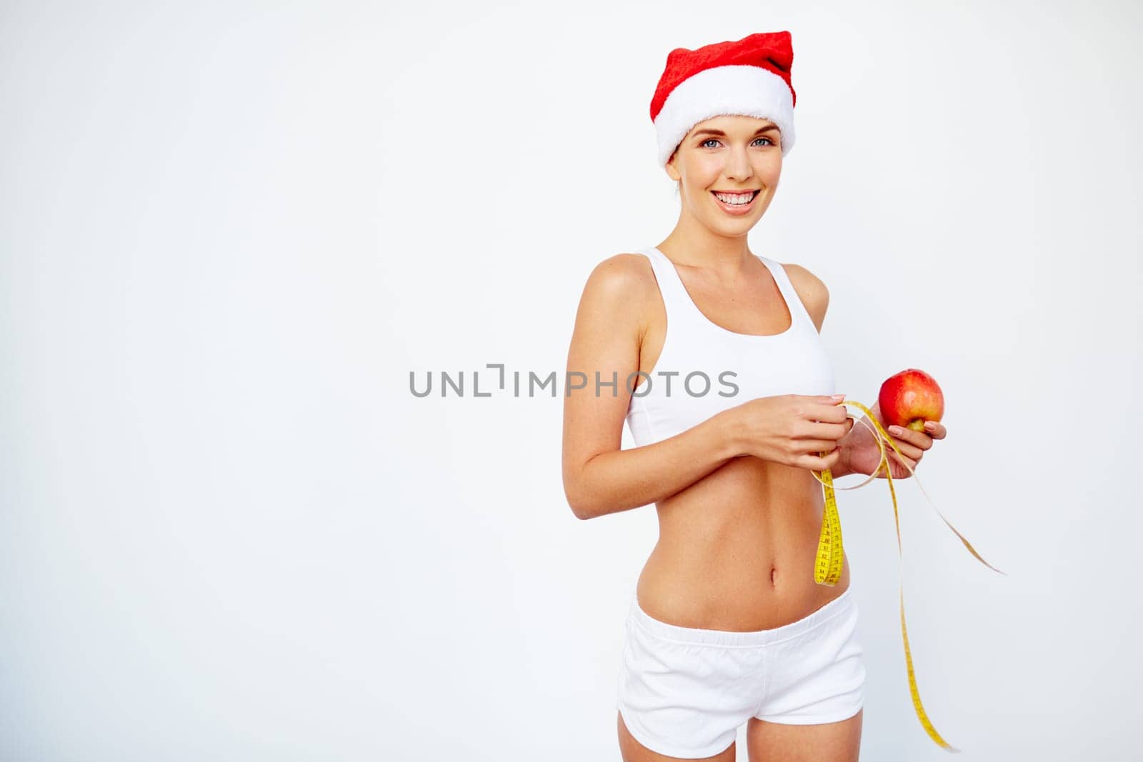Charming girl with red apple and measuring tape looking at camera