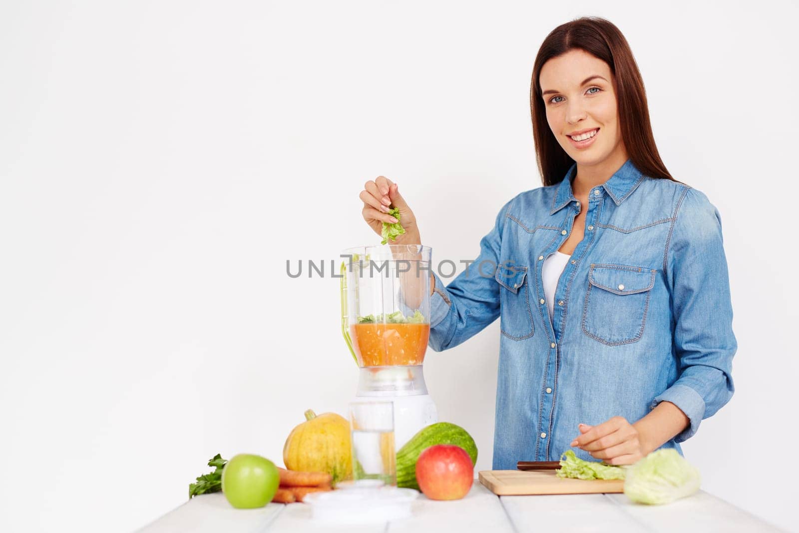 Pretty girl putting cut Chinese cabbage into vegetable smoothie