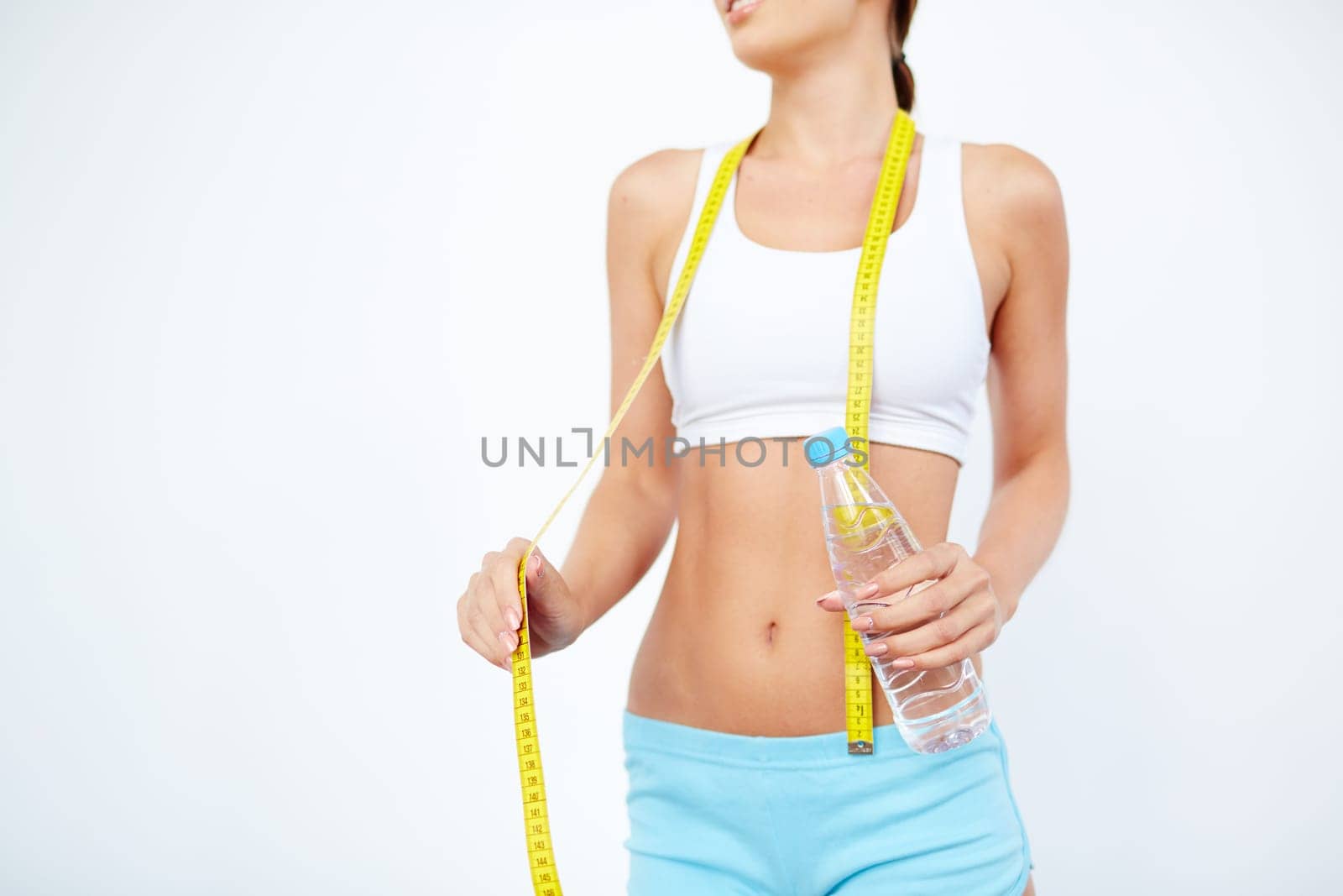 Slender girl with bottle of water and measuring tape