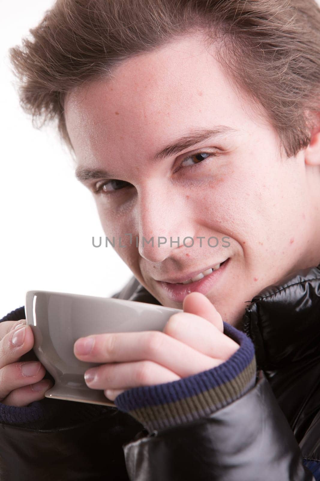 portrait of a good looking young man having a hot drink in winter