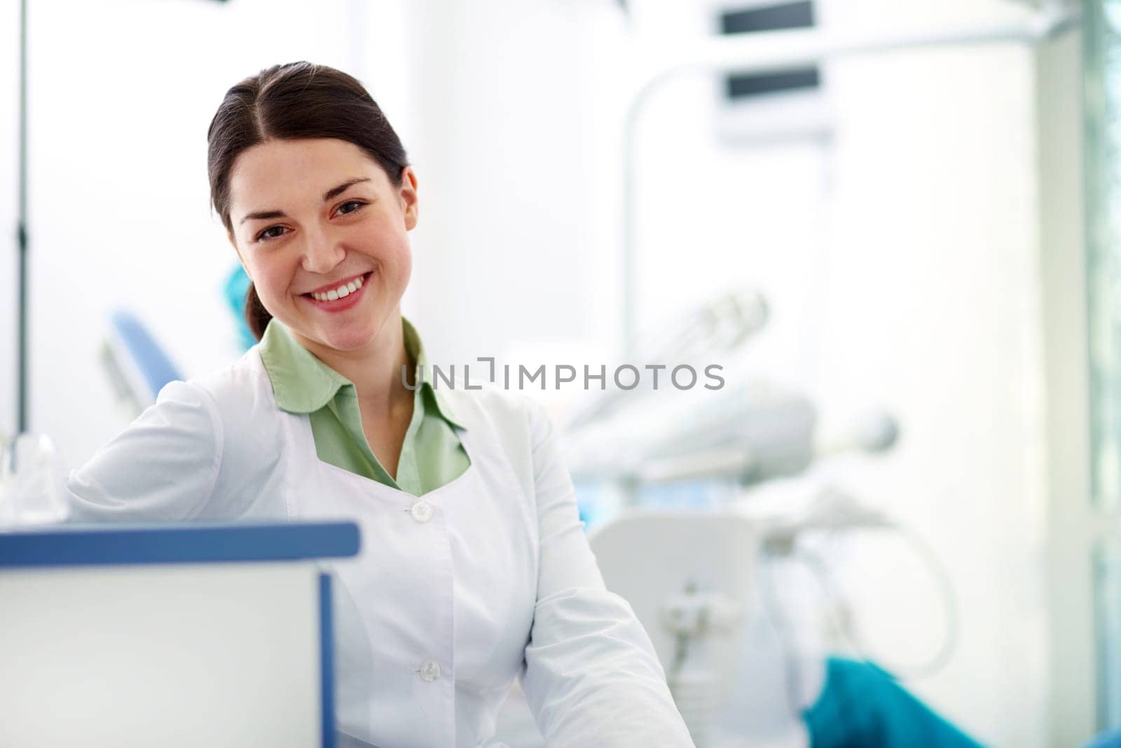 Pretty assistant in uniform looking at camera in hospital