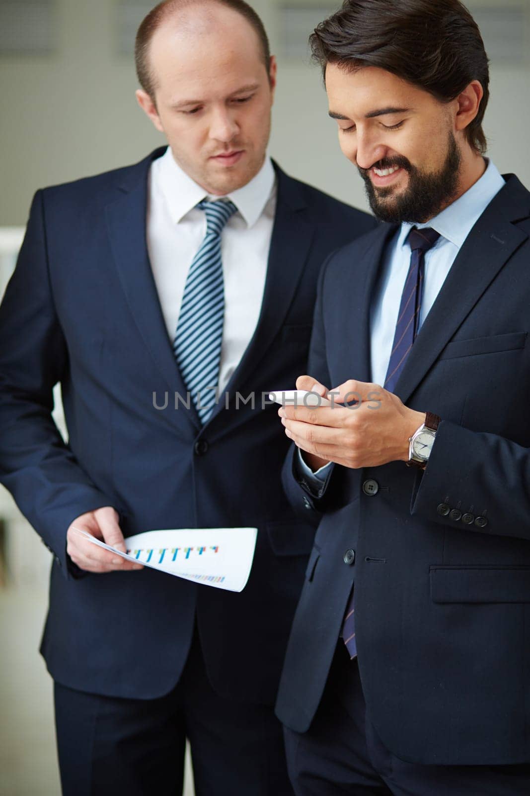 Two male employees using cellphone