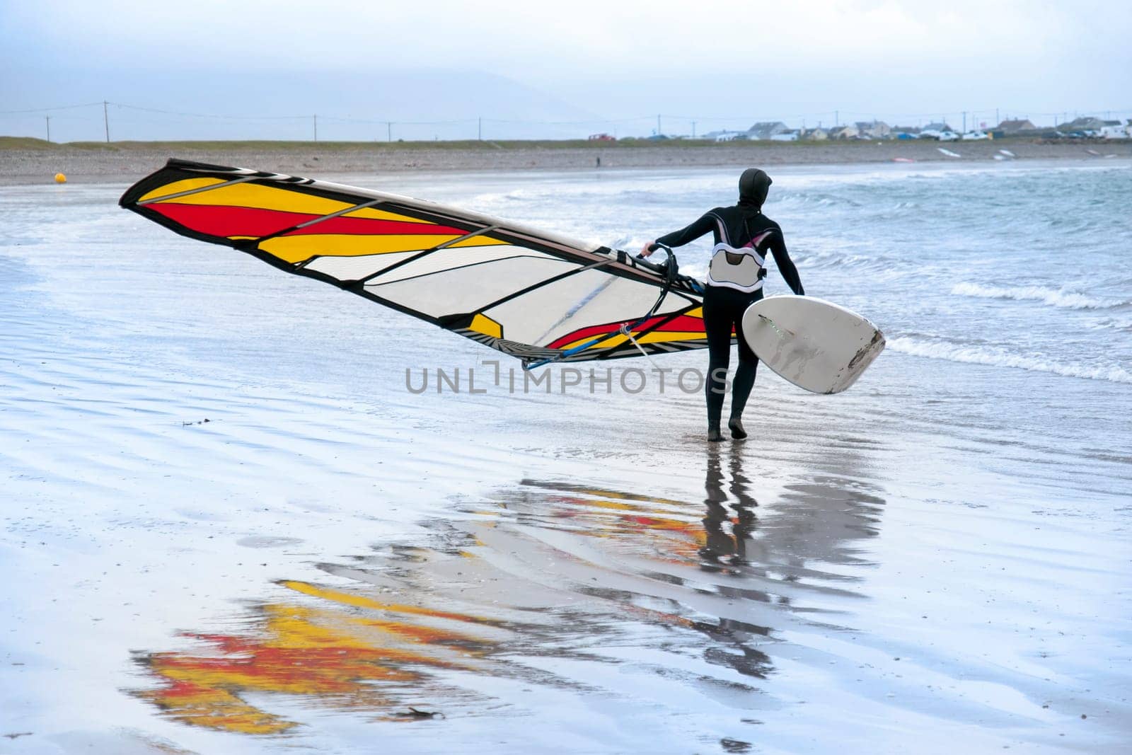 lone windsurfer getting ready to surf on the beach in the maharees county kerry ireland