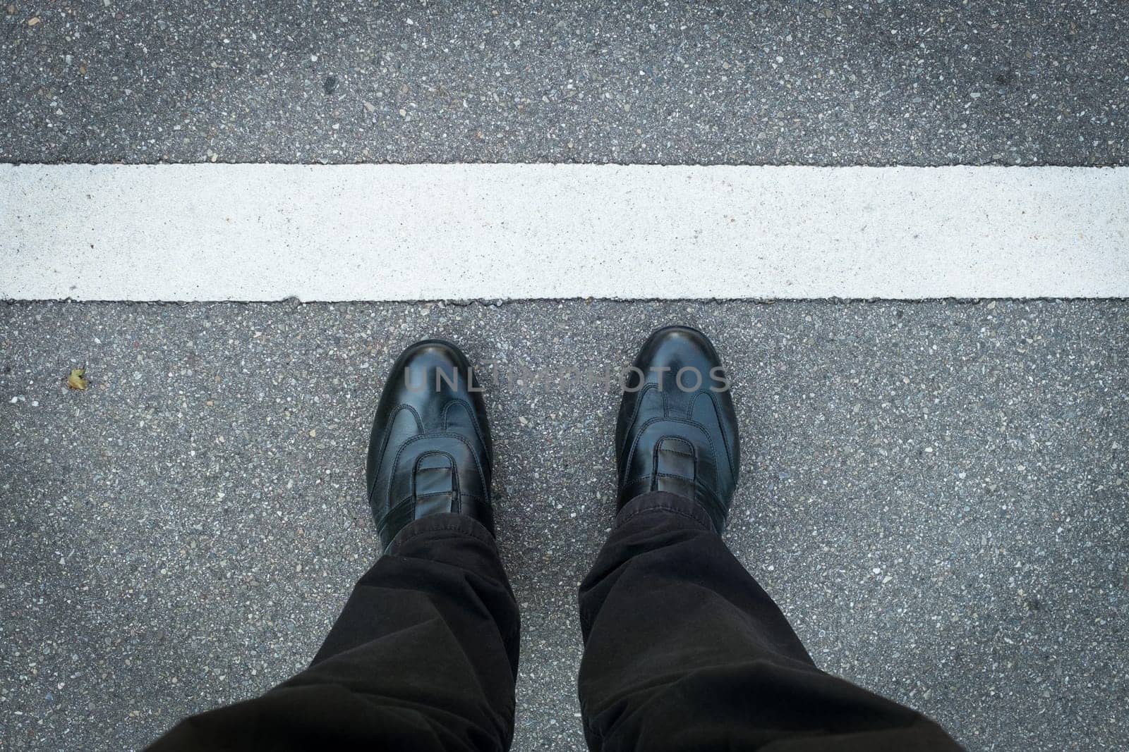 2 legs with shoes stand on the strip in white
