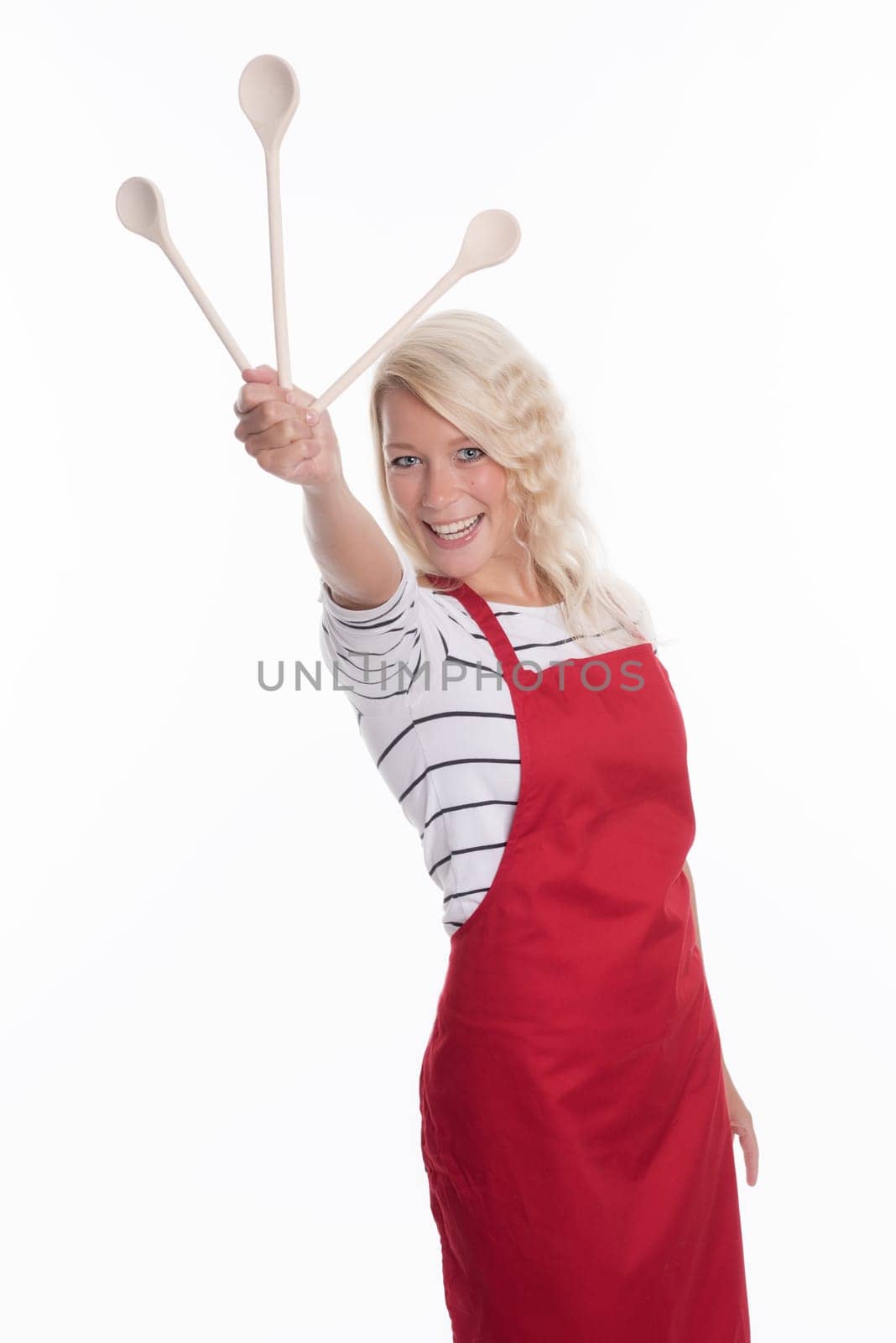 Housewife in apron holding various wooden spoons