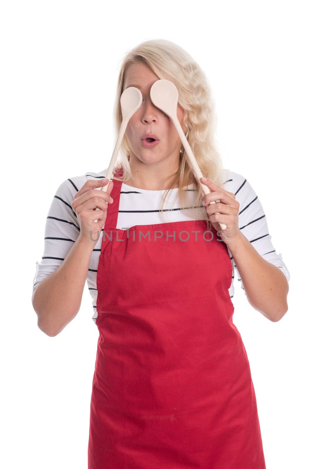 Housewife in apron holds cooking spoon in front of her eyes