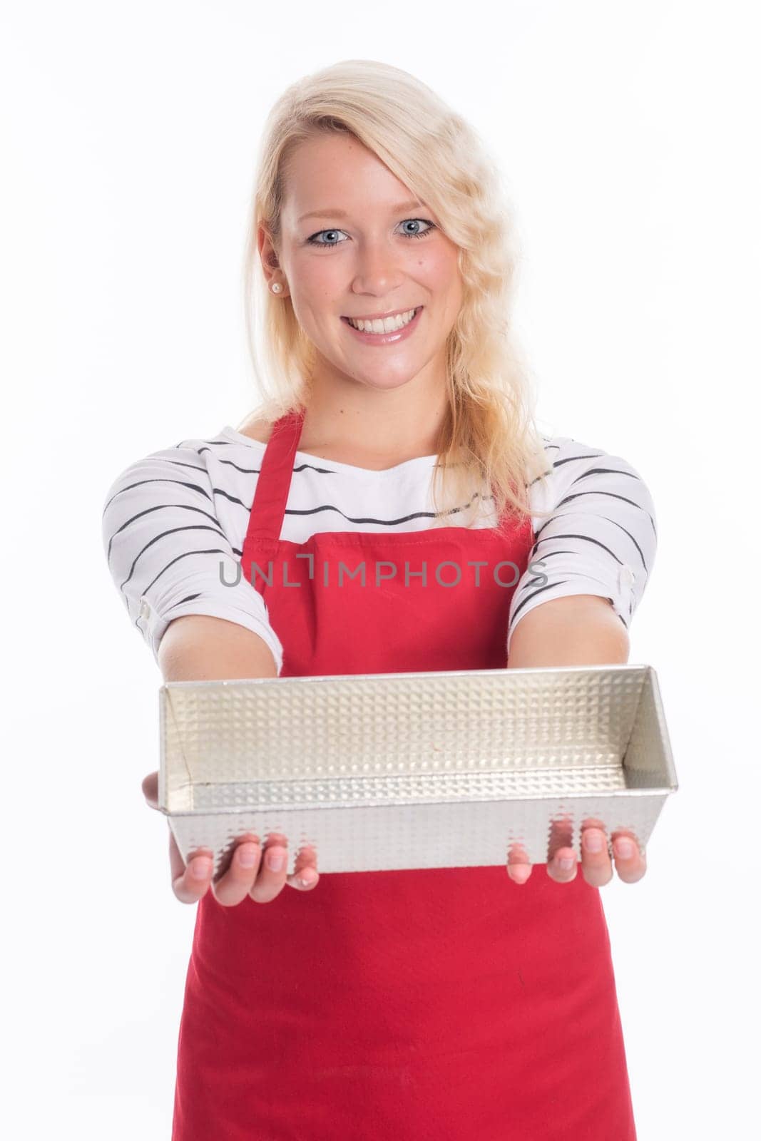 Housewife with apron holds a cake tin made of metal
