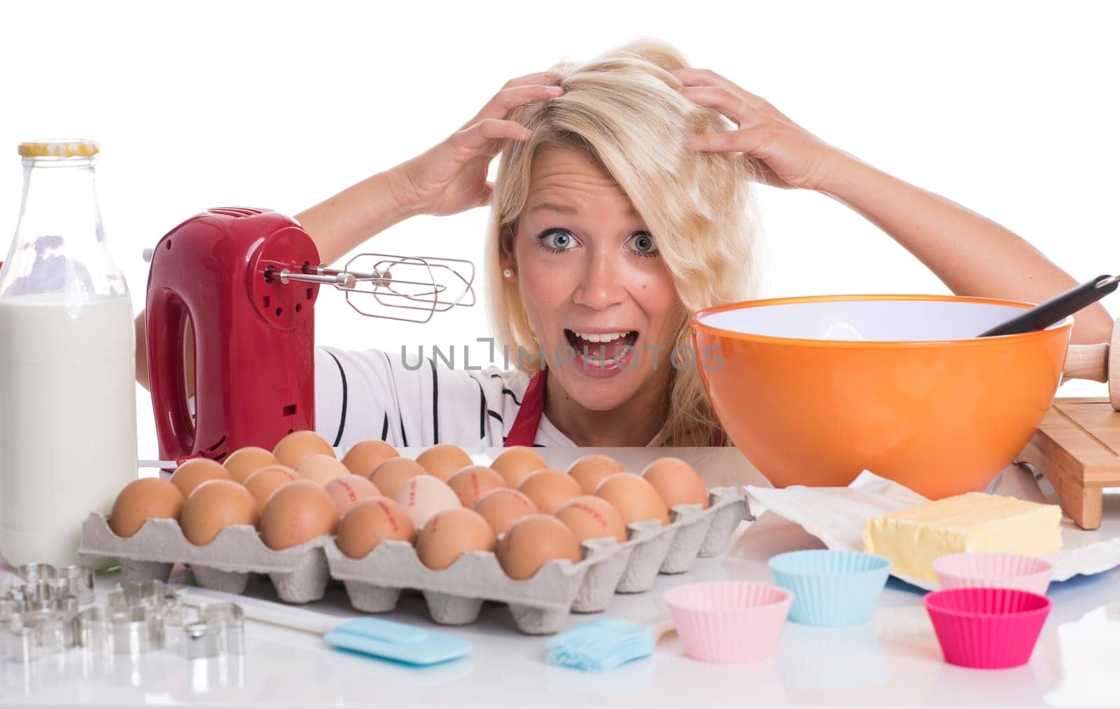 Young woman sits in front of baking ingredients and is overwhelmed