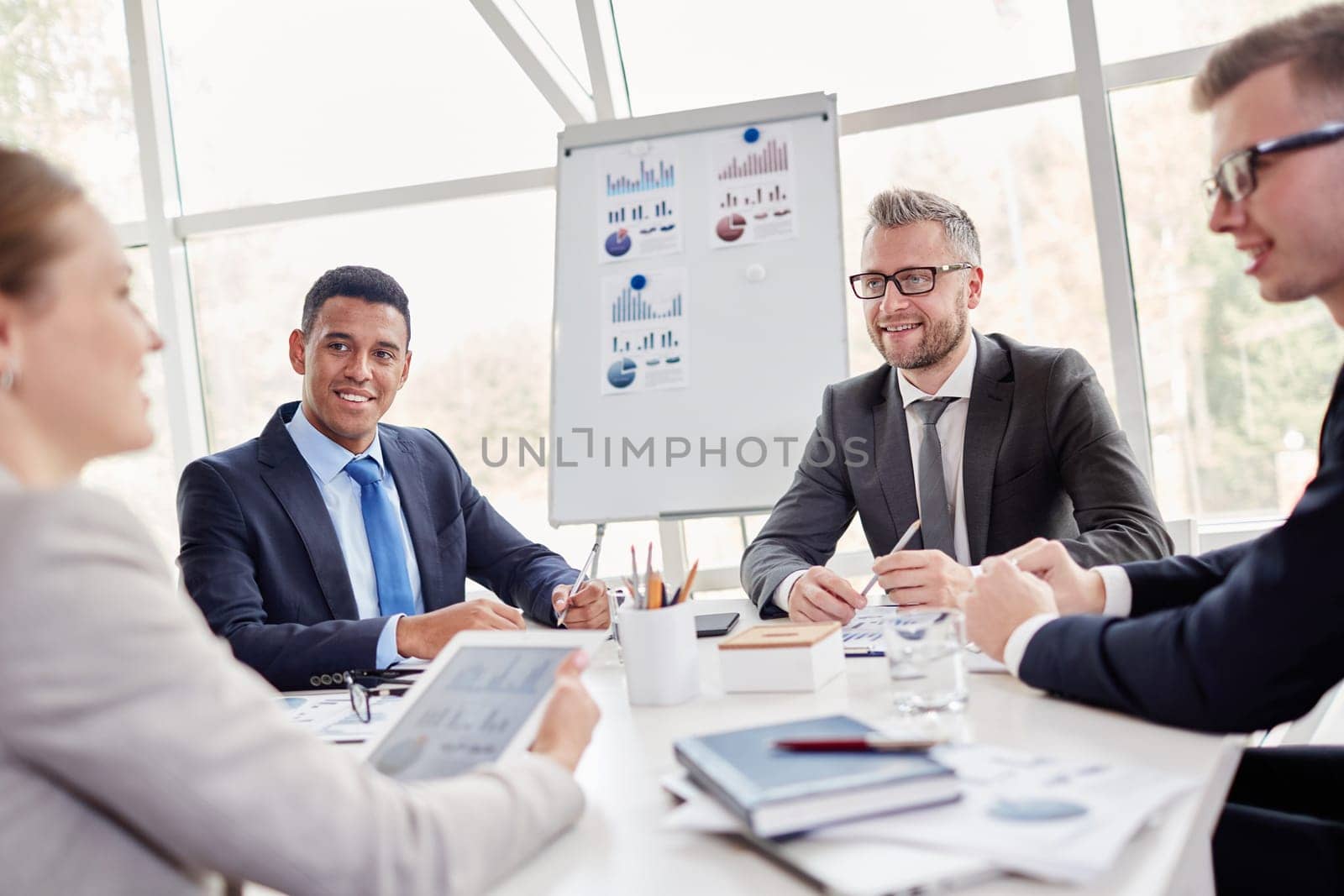 Group of confident employees listening to their colleague at meeting in office