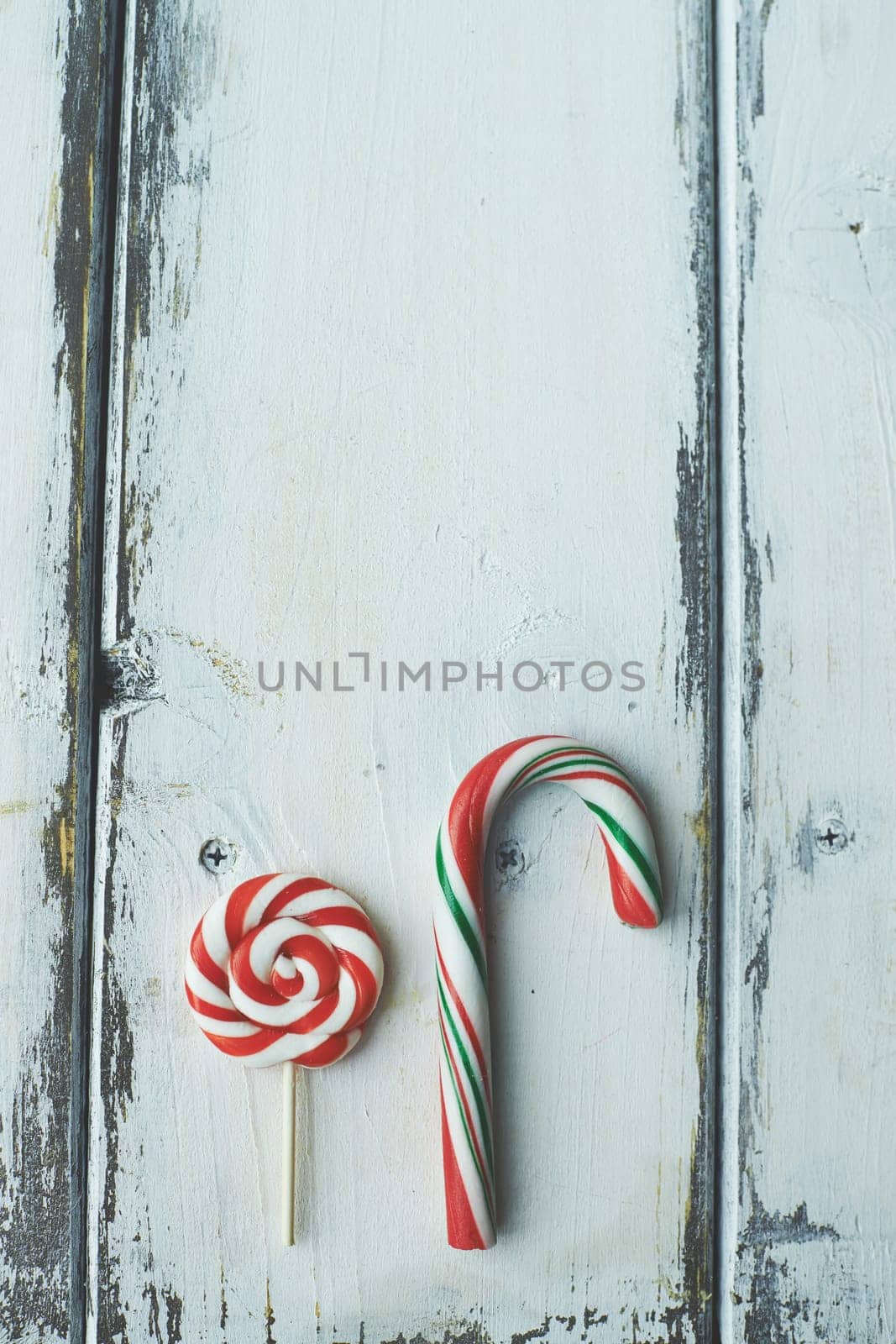 Sweet lollipop and candy cane on wooden background