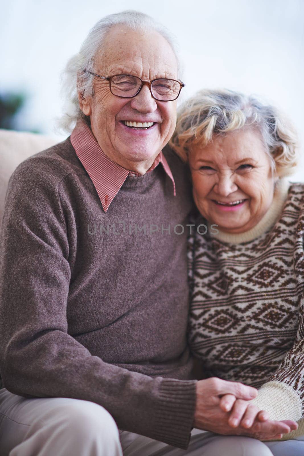 Happy elderly couple looking at camera and laughing