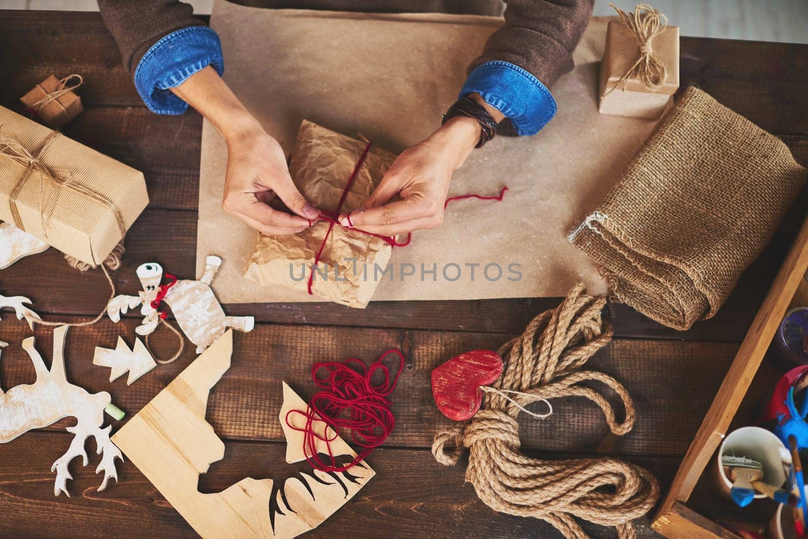 Hands of man tying up xmas gift wrapped into paper