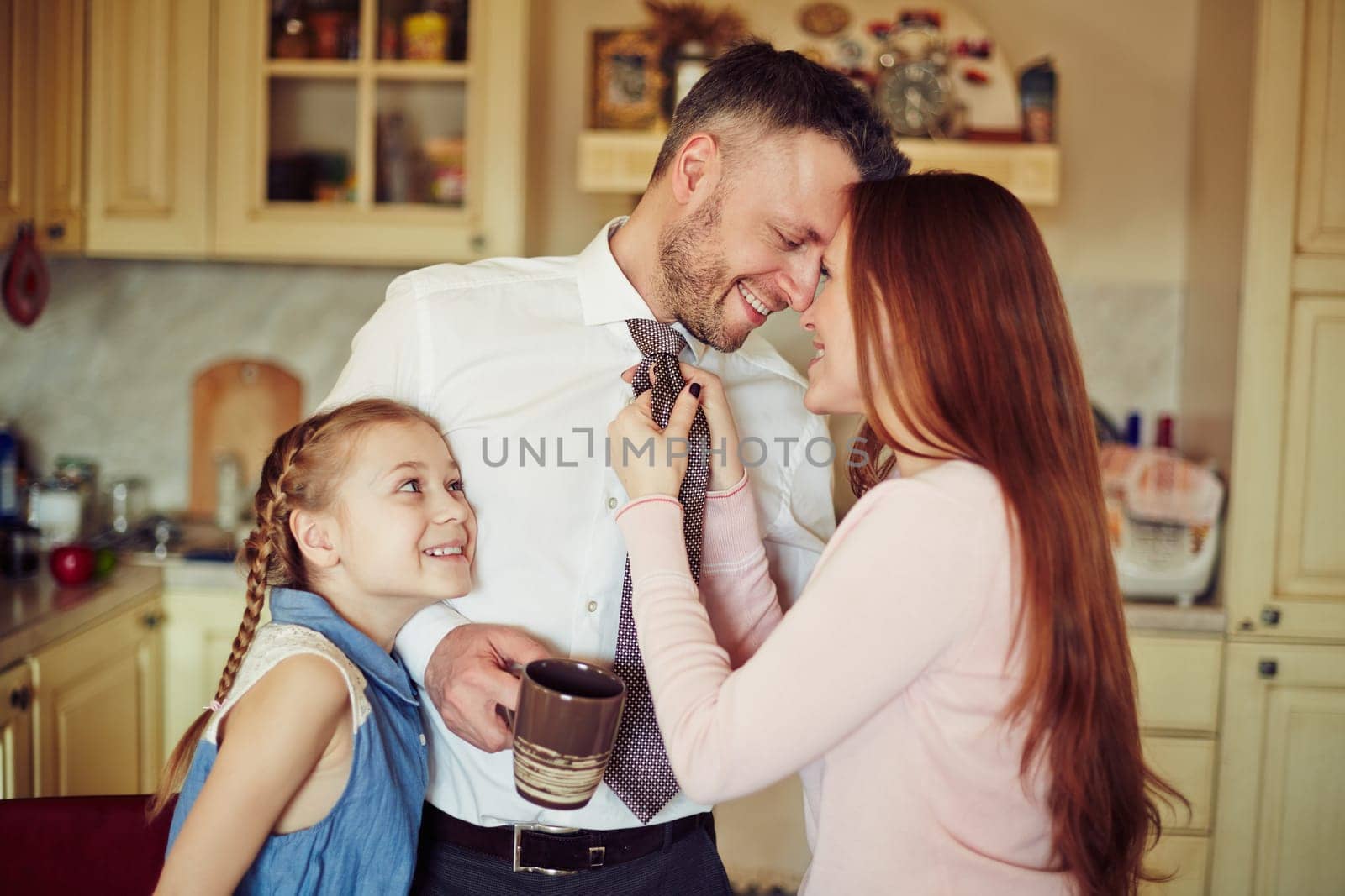 Happy couple and their daughter in the kitchen