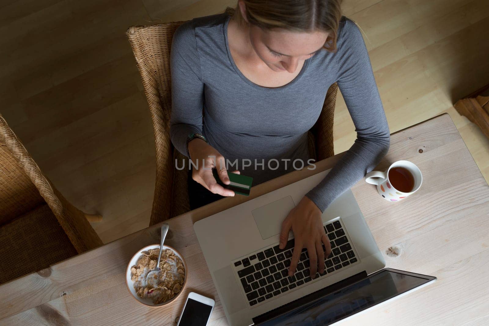 Ariel view of a woman using her laptop to make an online card payment.