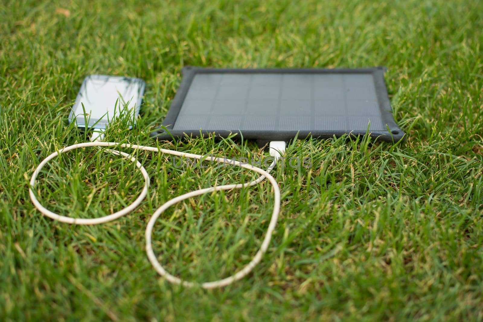 Use of renewable energy - Mobile Phone Chargers on grass in nature with Sun