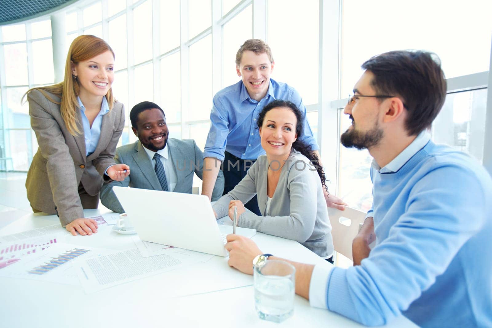 Group of managers looking at their colleague explaining data