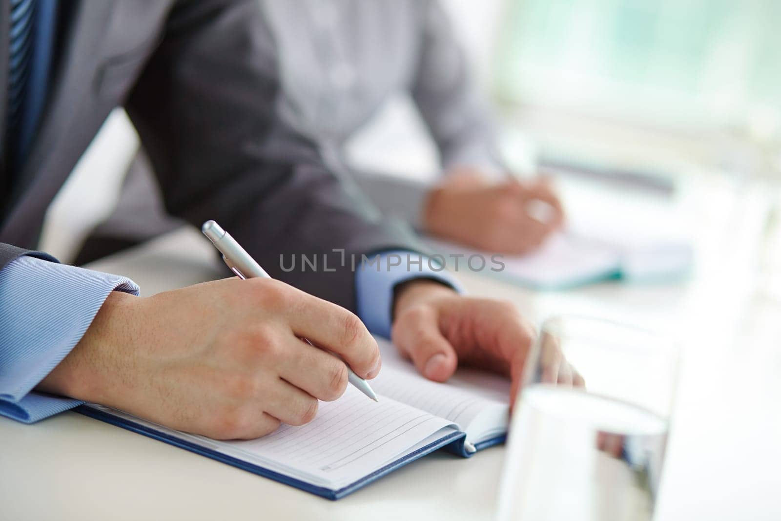 Male hand with pen over blank notebook page