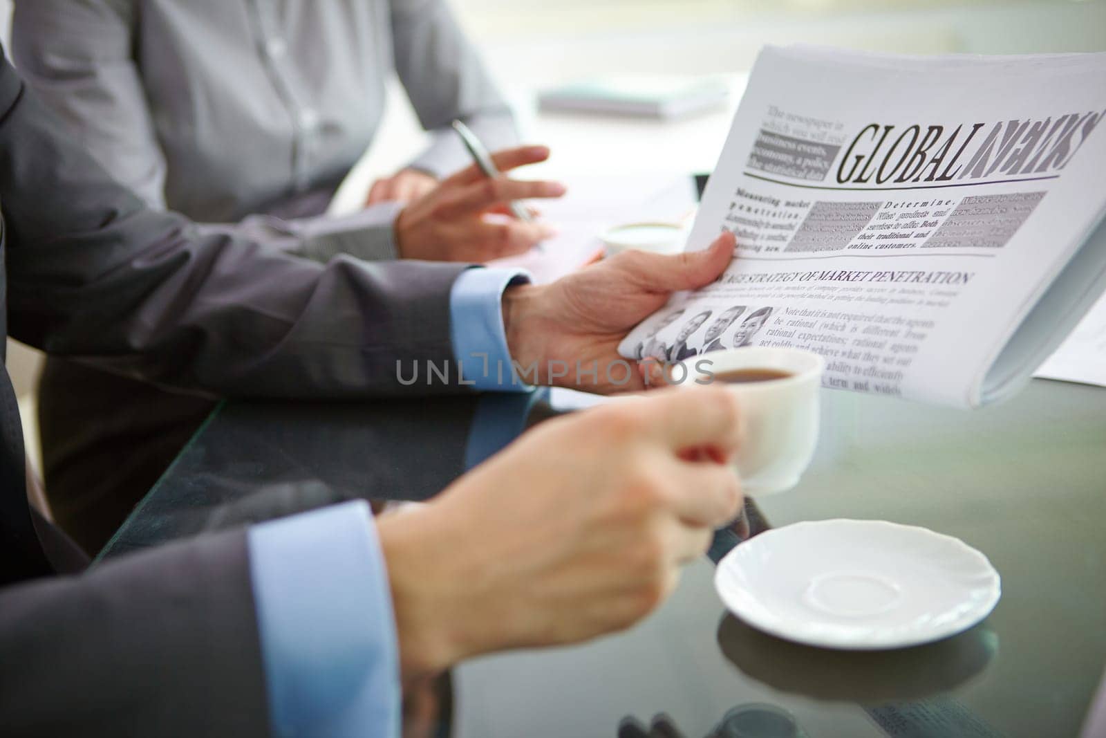 Businessman having morning coffee while reading latest news