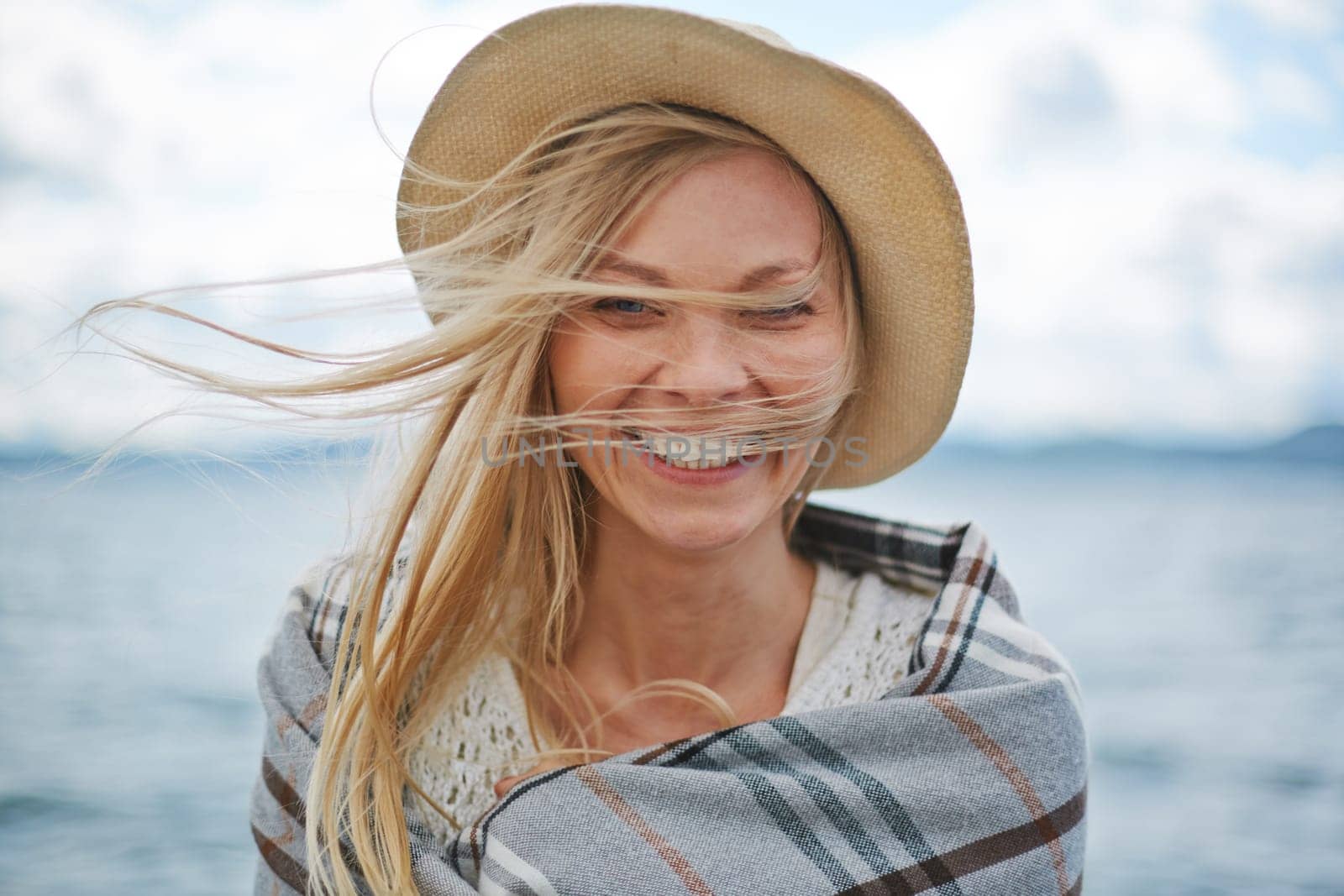 Blond girl in hat looking at camera outdoors