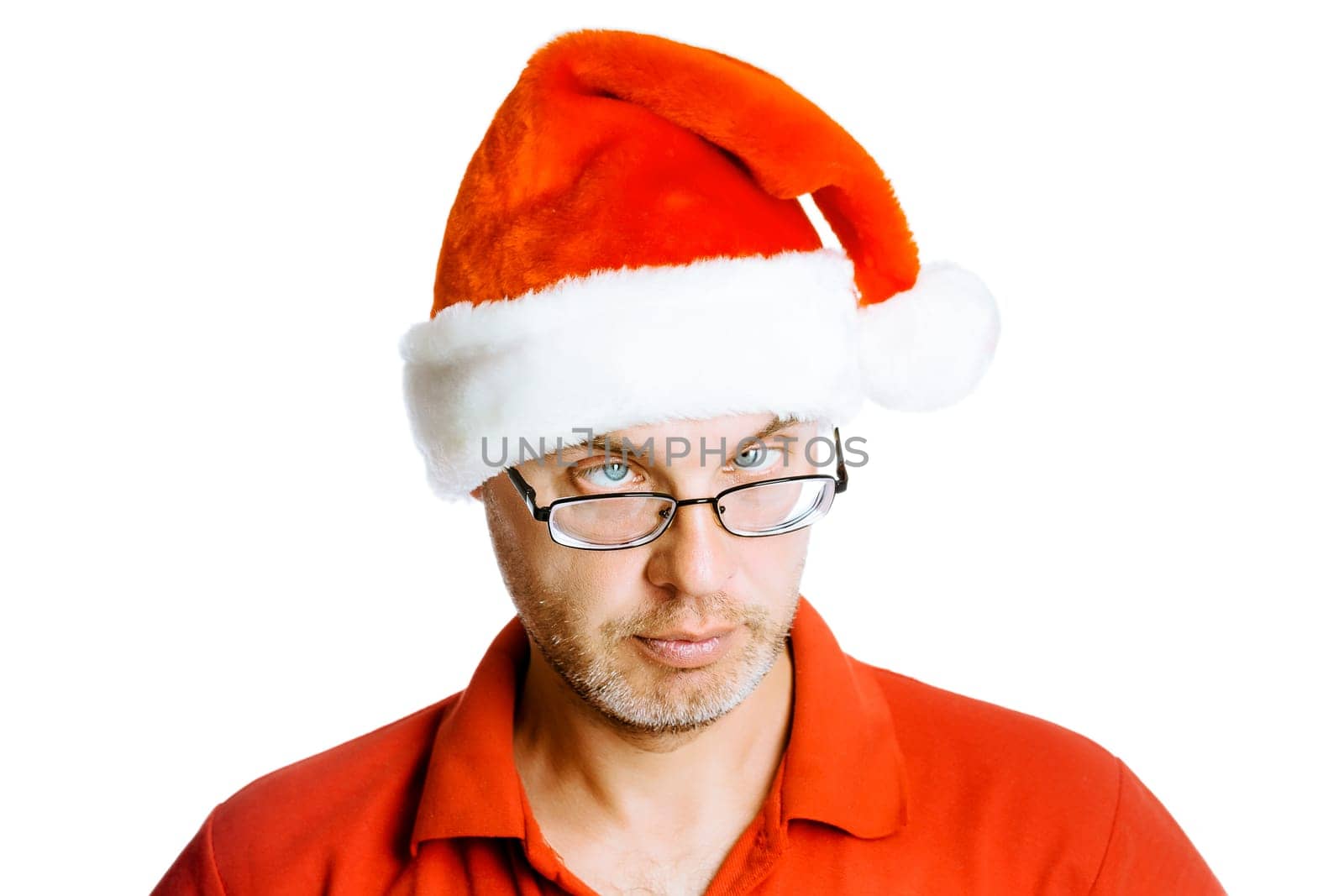 Unshaven slanting eyes Man in Santa hat. Isolated on white. Studio. Humor