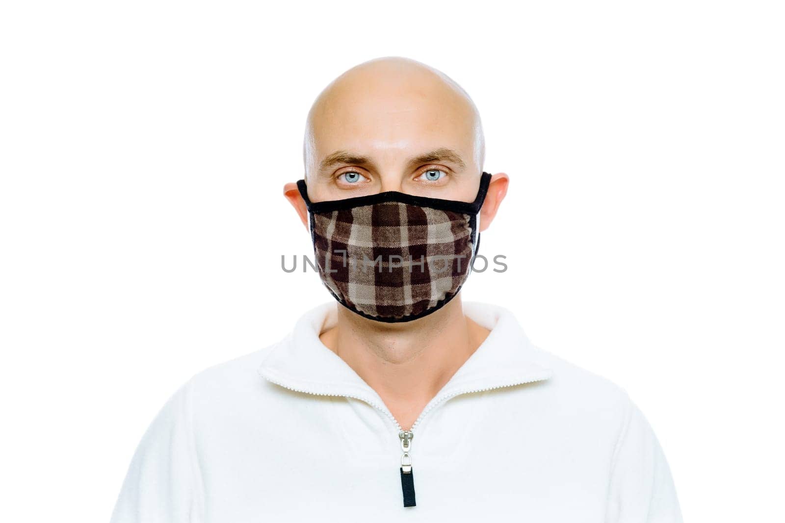 Bald, blue-eyed man in a white jacket and mask. Studio. isolated