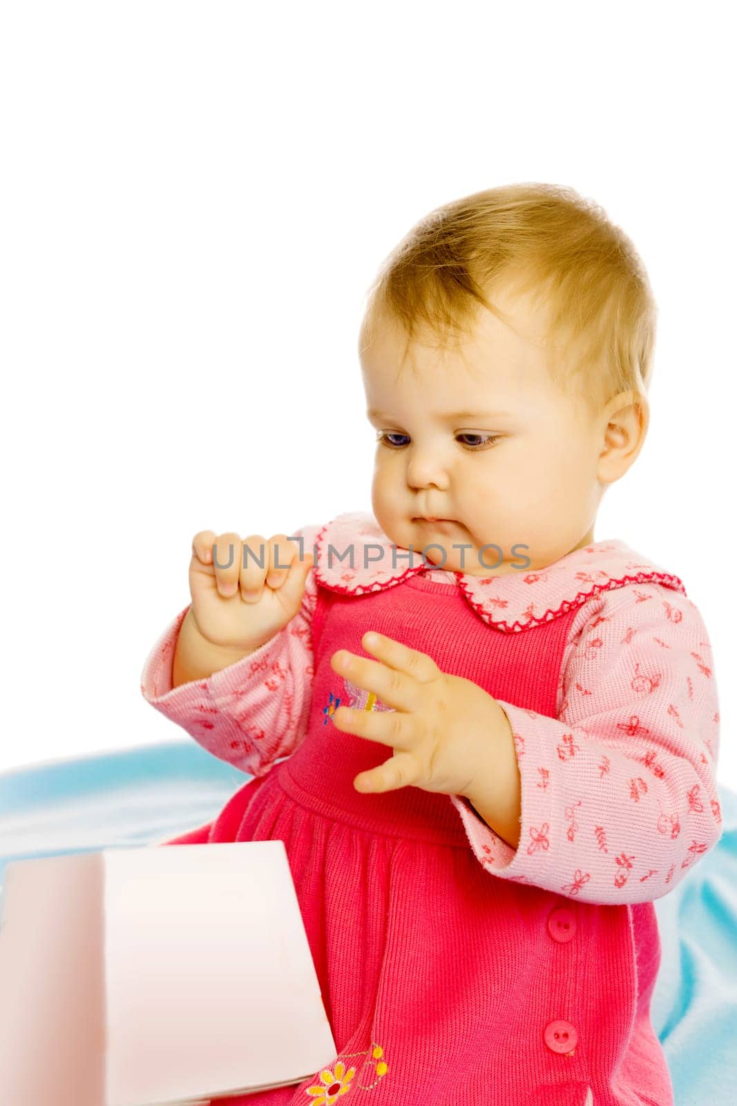 baby girl in a dress sitting and holding a box