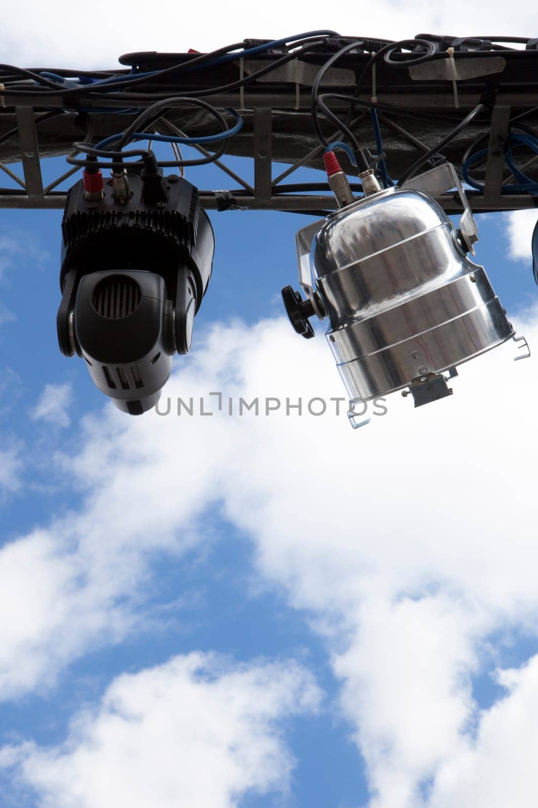 Spot light system on white isolated over blue cloudy sky with space for text